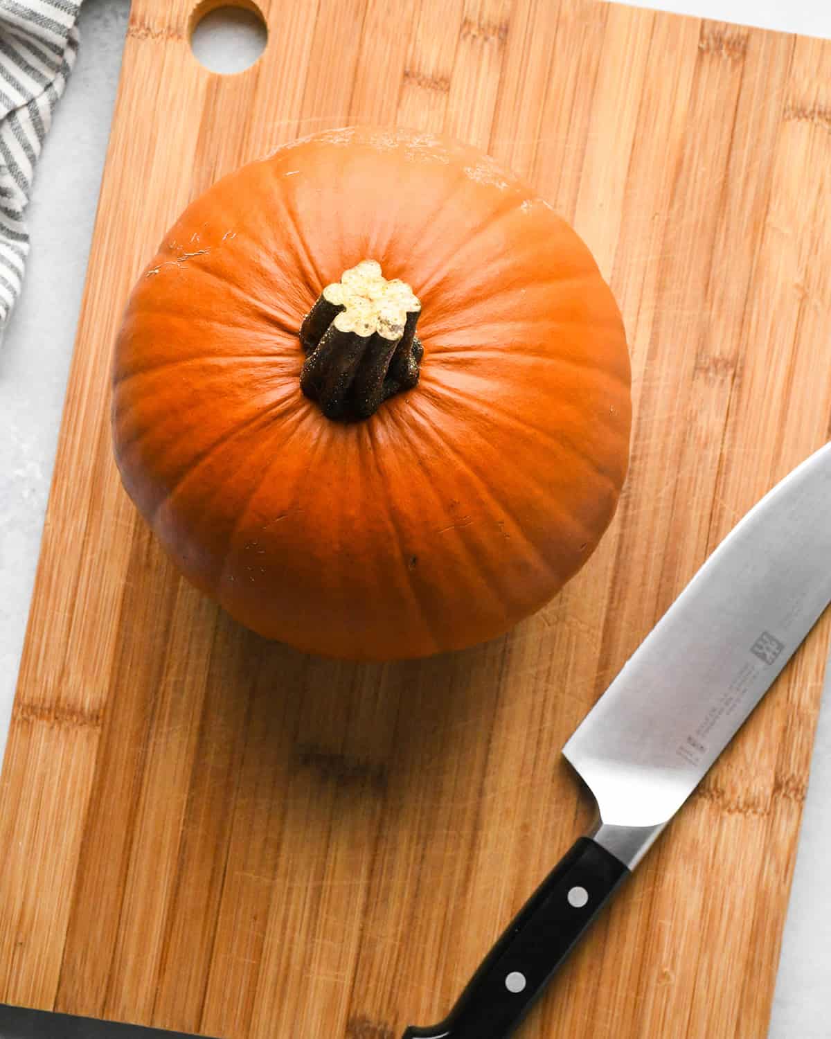 How to Make Pumpkin Puree - a whole pie pumpkin on a cutting board with a knife
