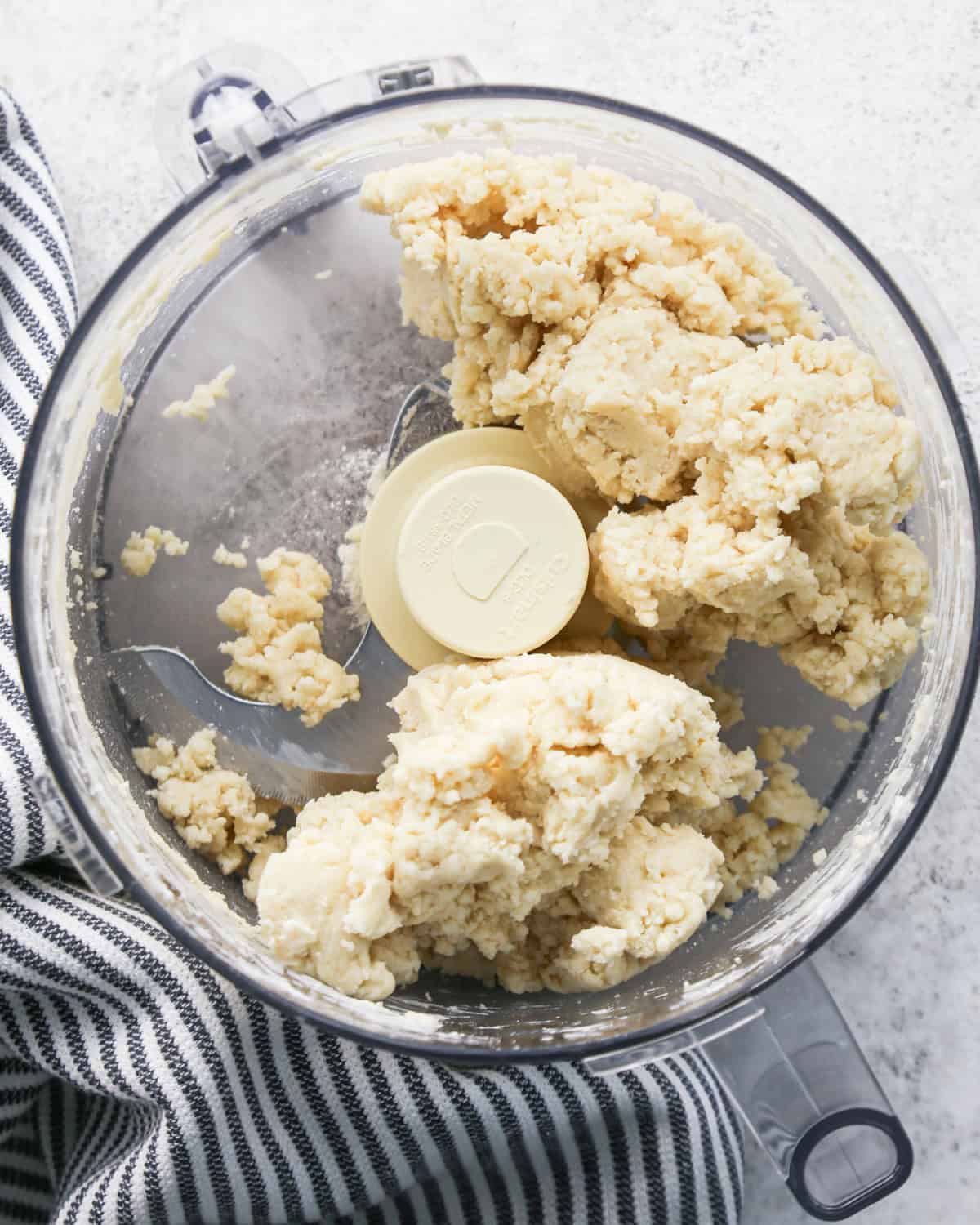 pie crust dough in a food processor to be used to make pie crust cookies.