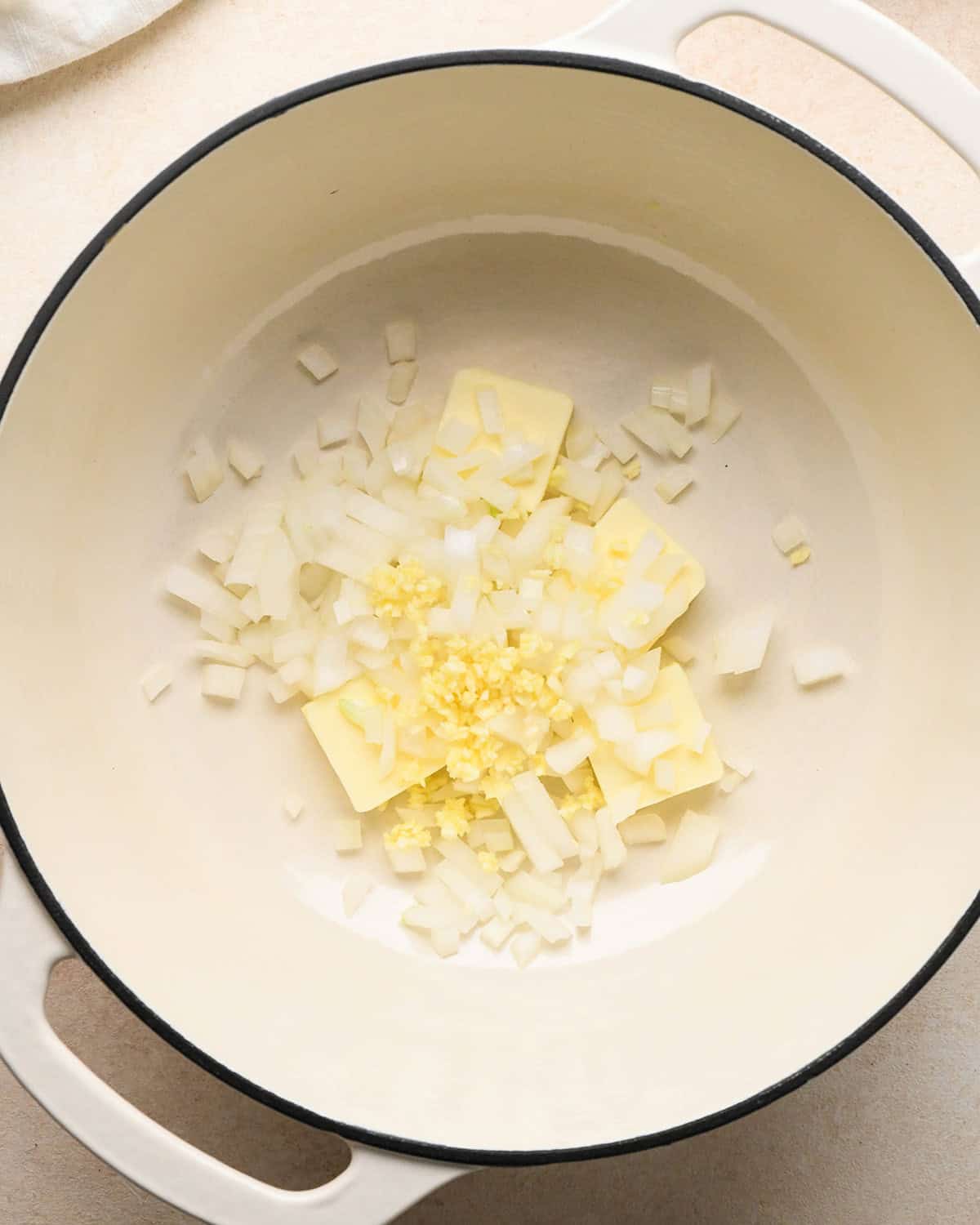 onion, minced garlic and butter in a white pot before cooking to make pumpkin mac and cheese