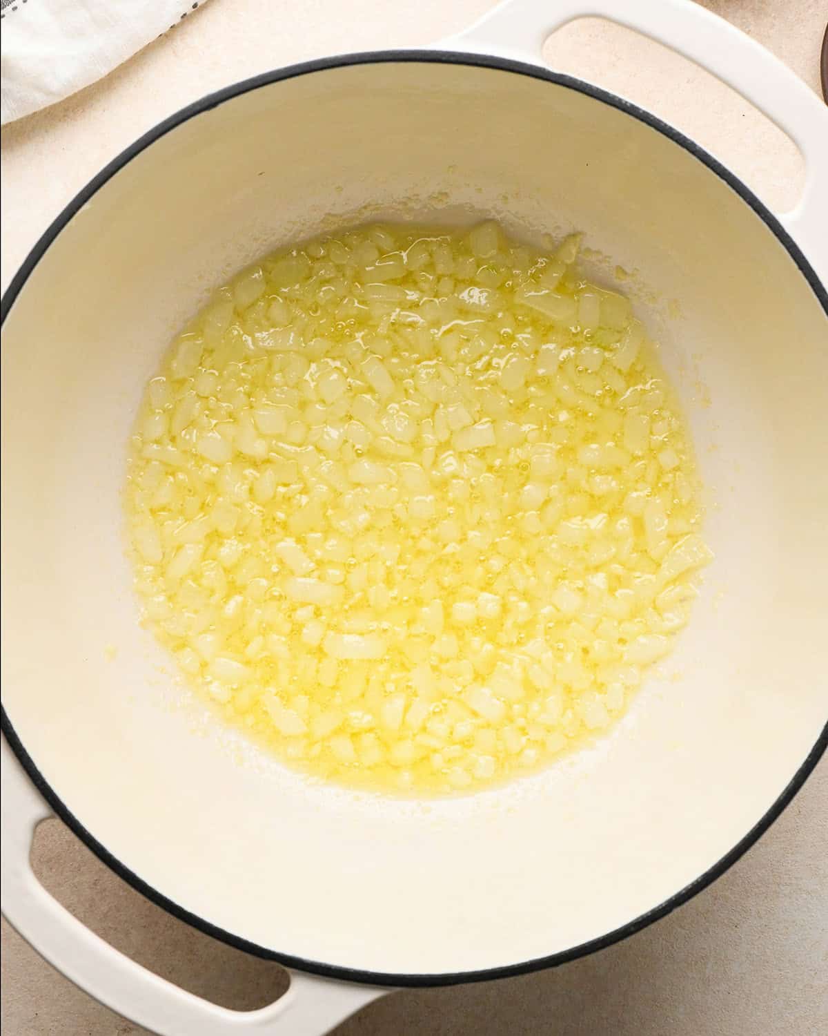 onion, minced garlic and butter in a white pot after butter has melted to make pumpkin mac and cheese