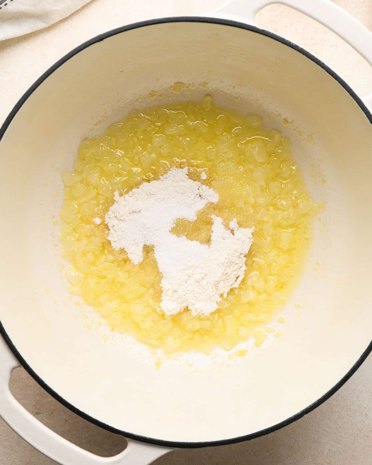 flour and salt added to the melted butter and onion mixture in a white pot to make pumpkin macaroni and cheese