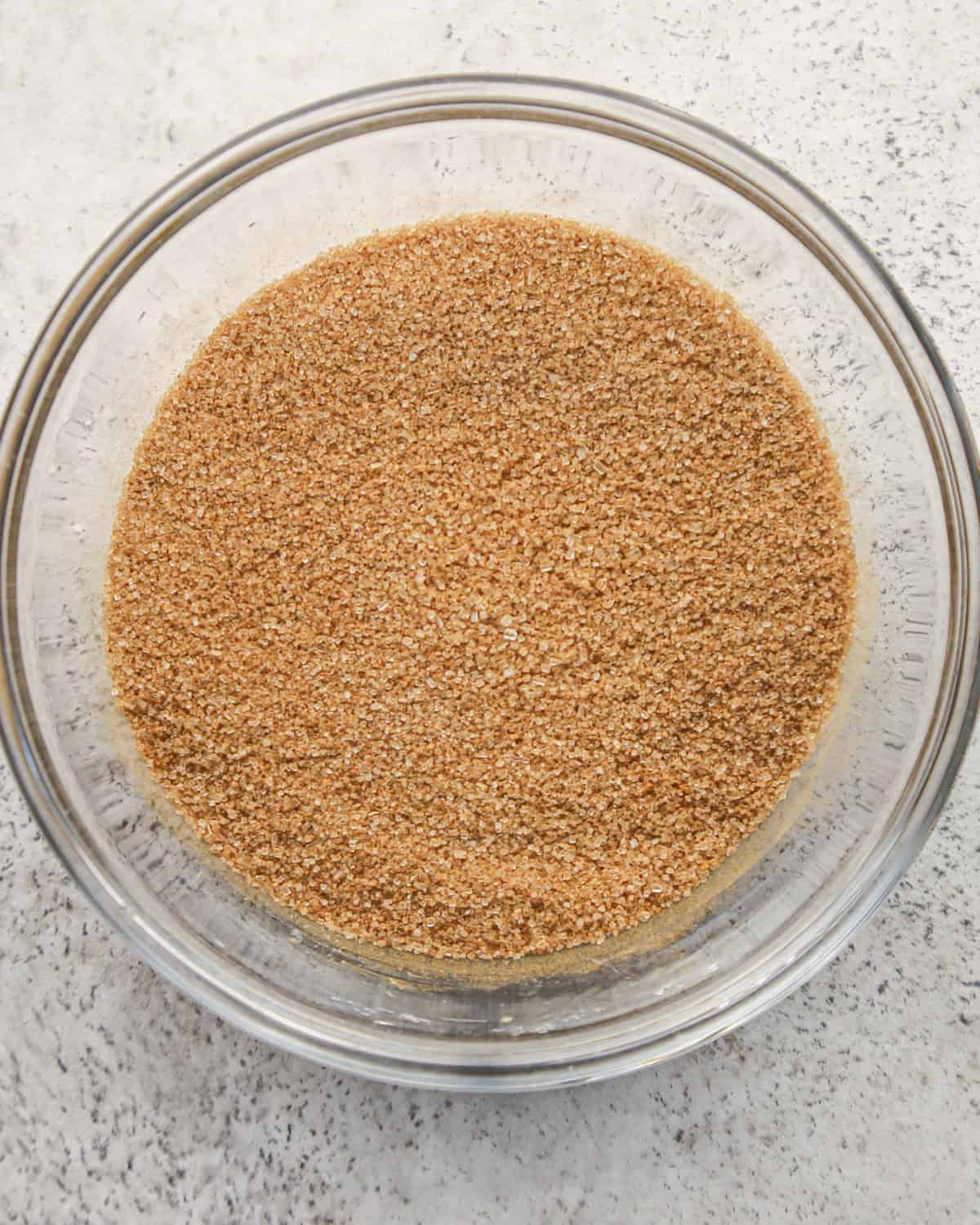 cinnamon and sugar in a glass bowl on a gray surface after mixing