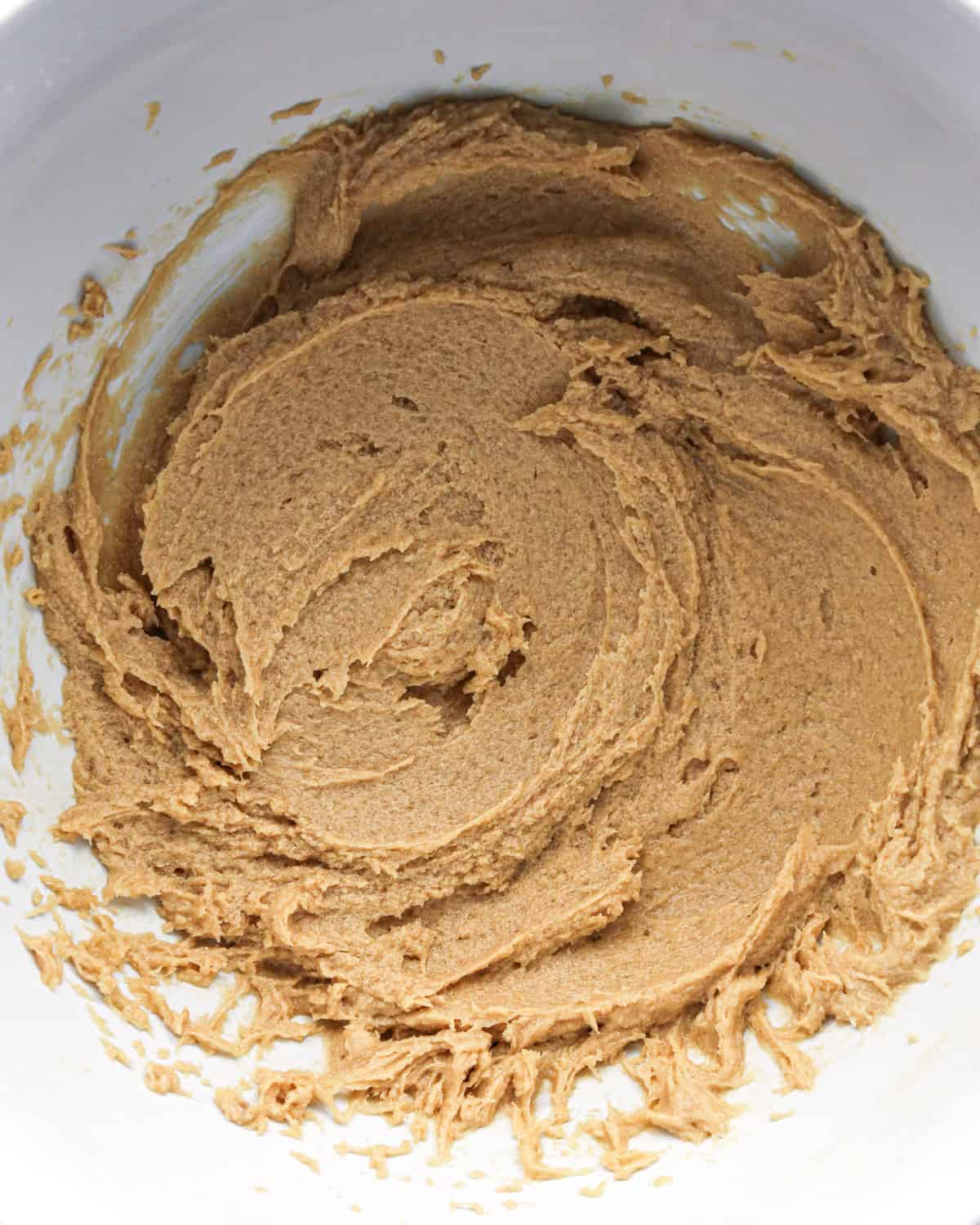 beaten butter, sugar, egg and vanilla mixture in a white bowl making pumpkin snickerdoodles