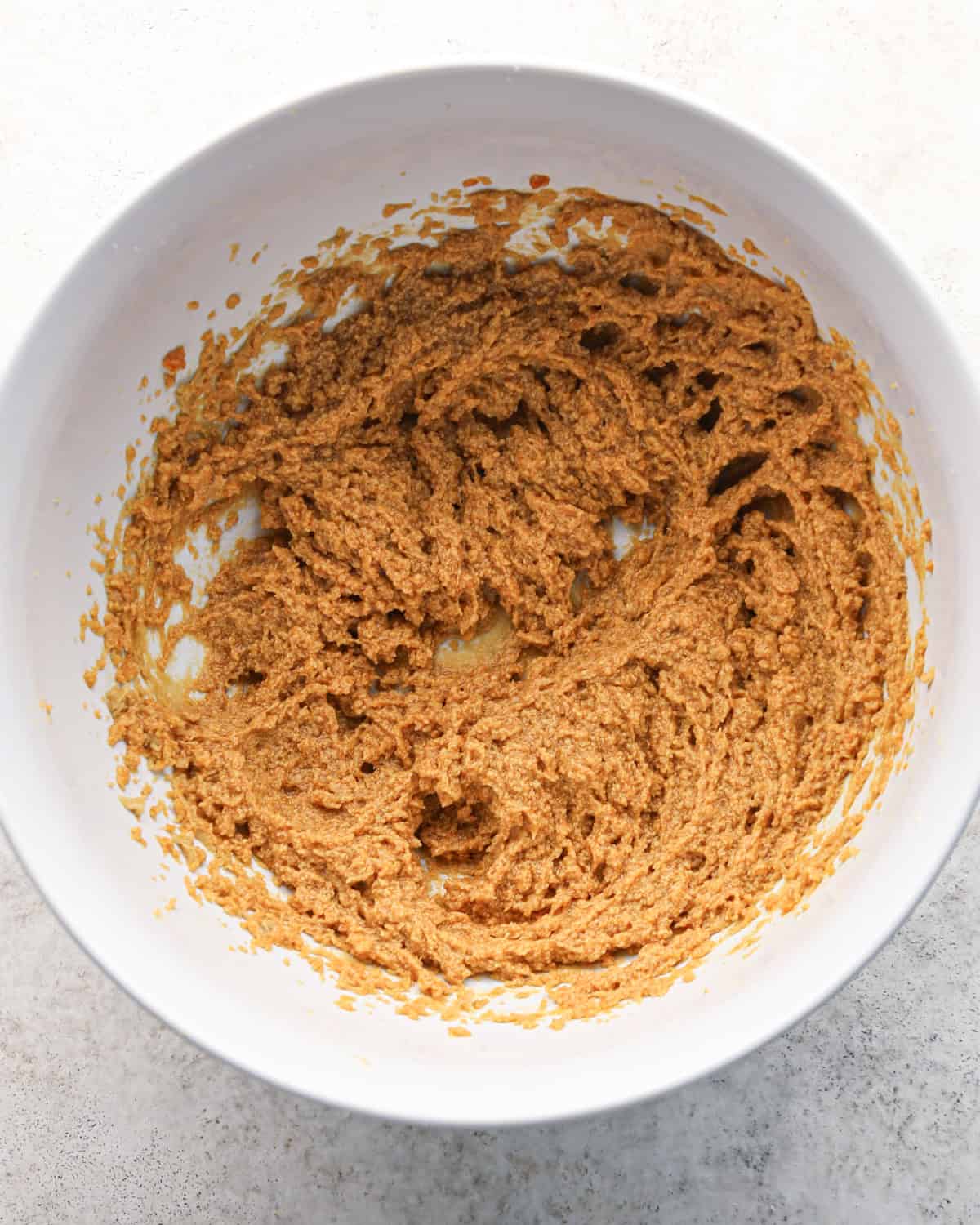 beaten wet ingredients in a white bowl making pumpkin snickerdoodles