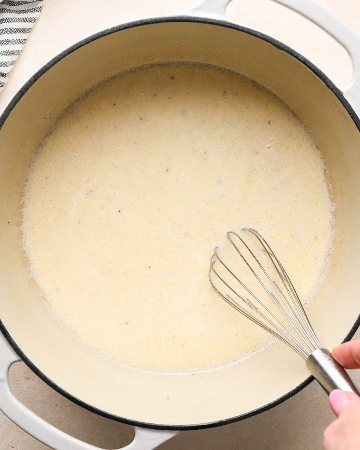 sour cream and milk added to the flour and bacon grease mixture to make bacon macaroni and cheese after whisking