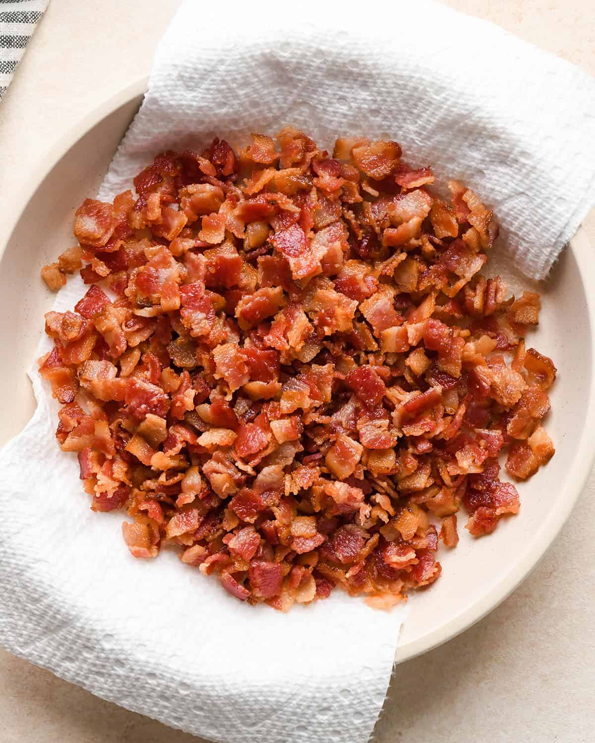 cooked diced bacon on a paper-towel lined plate for bacon macaroni and cheese