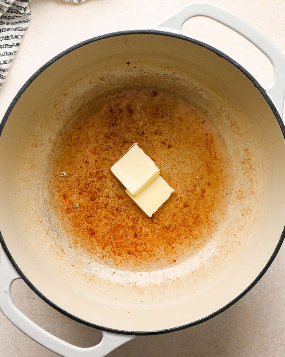 two square of butter in a pot with bacon grease to make bacon macaroni and cheese