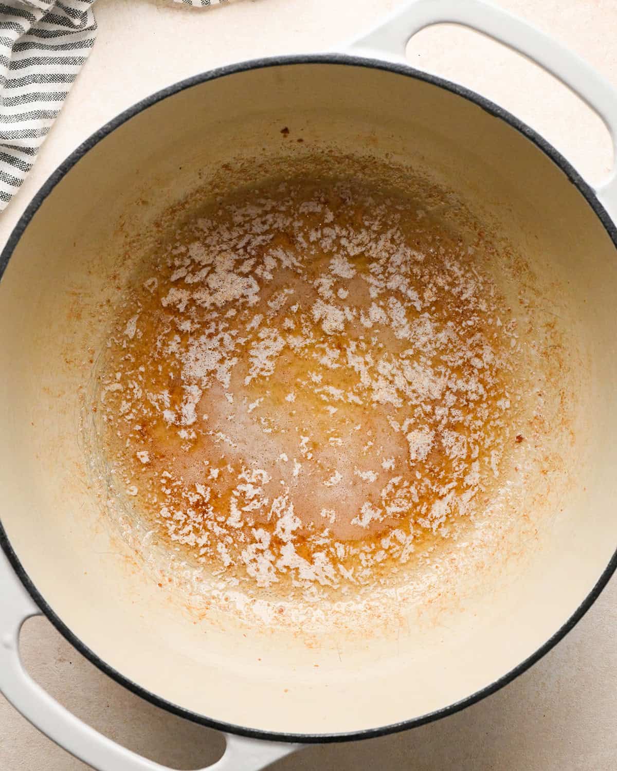 melted butter and bacon grease in a white pot to make bacon mac and cheese