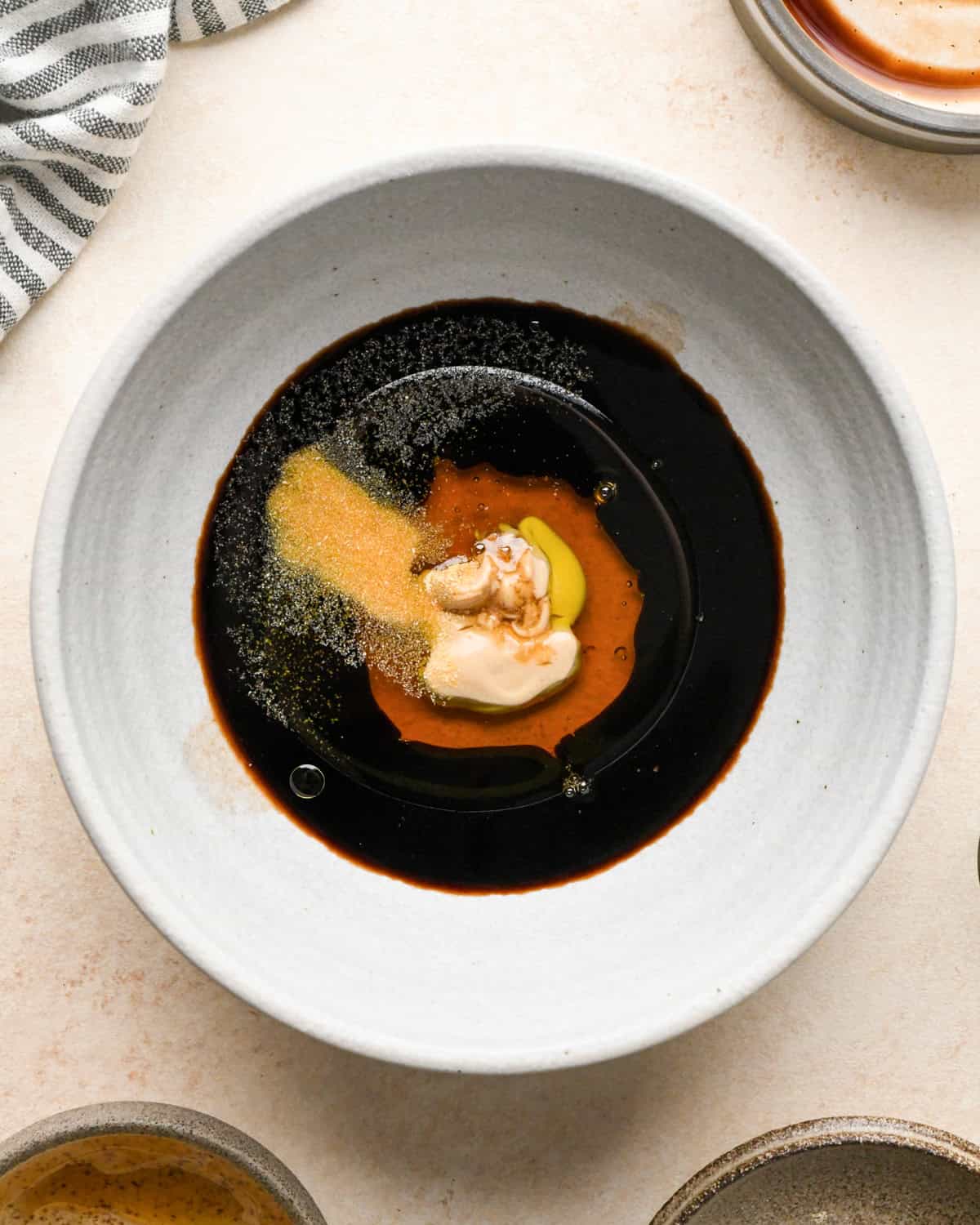 balsamic vinegar, oil, mustard, honey and spices in a small white ceramic bowl before mixing making the dressing for beet salad