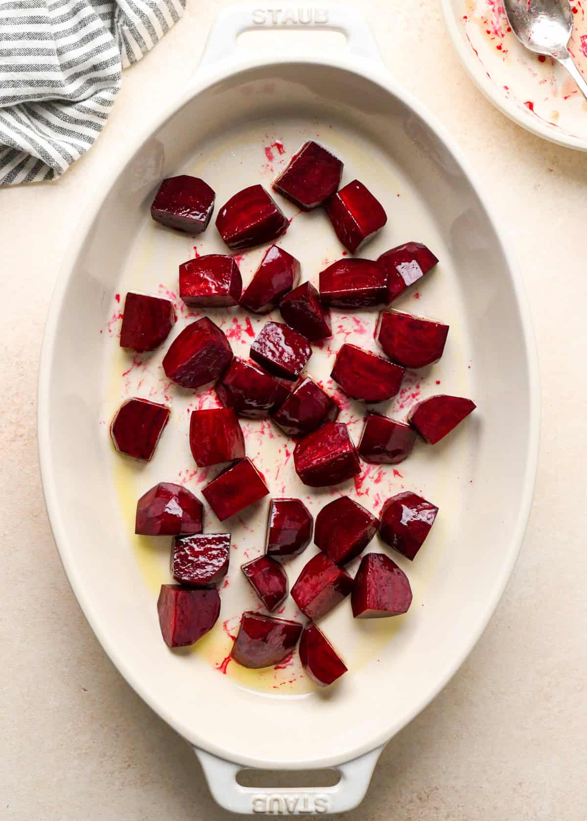 beets in a white, oval ceramic baking dish before baking to be used in a beet salad