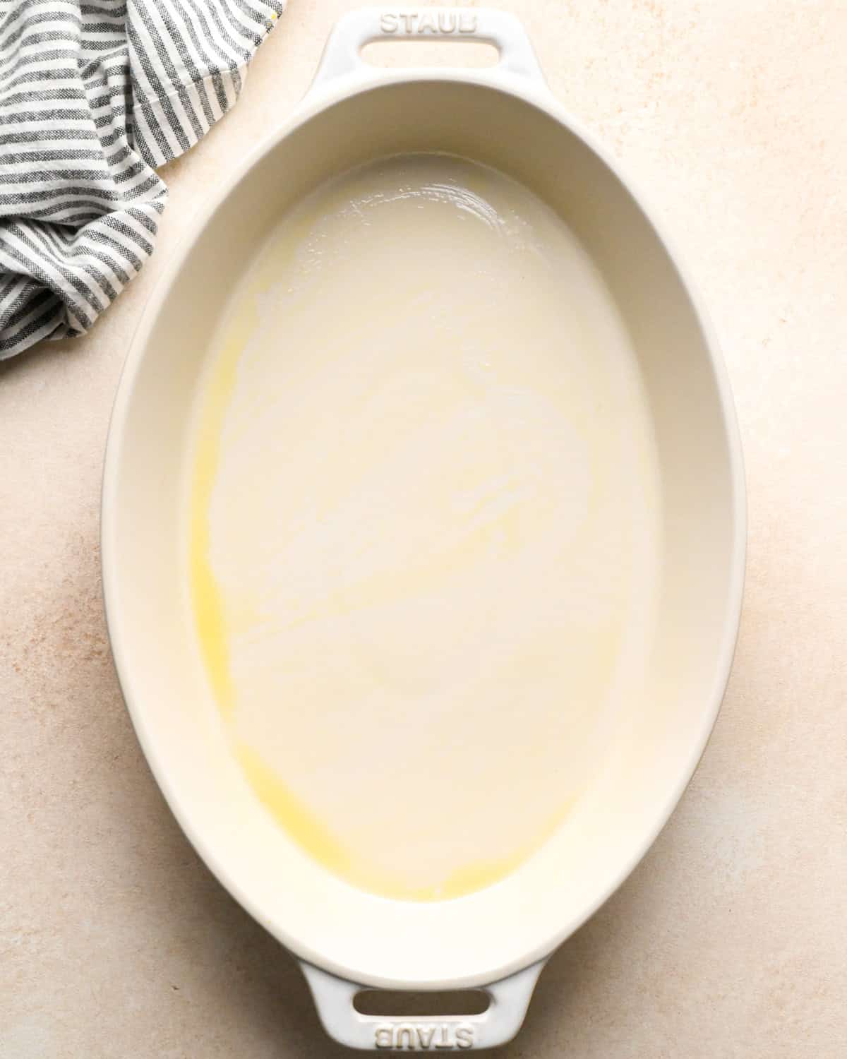 a white ceramic oval baking dish greased to roast beets in for beet salad.