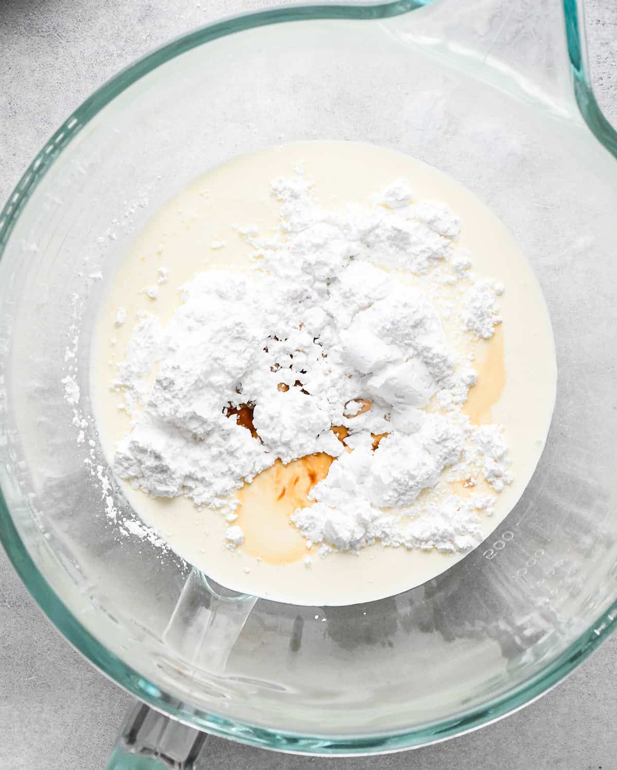 heavy cream, powdered sugar and vanilla in a glass mixing bowl before whipping to make the whipped cream topping for peanut butter pie