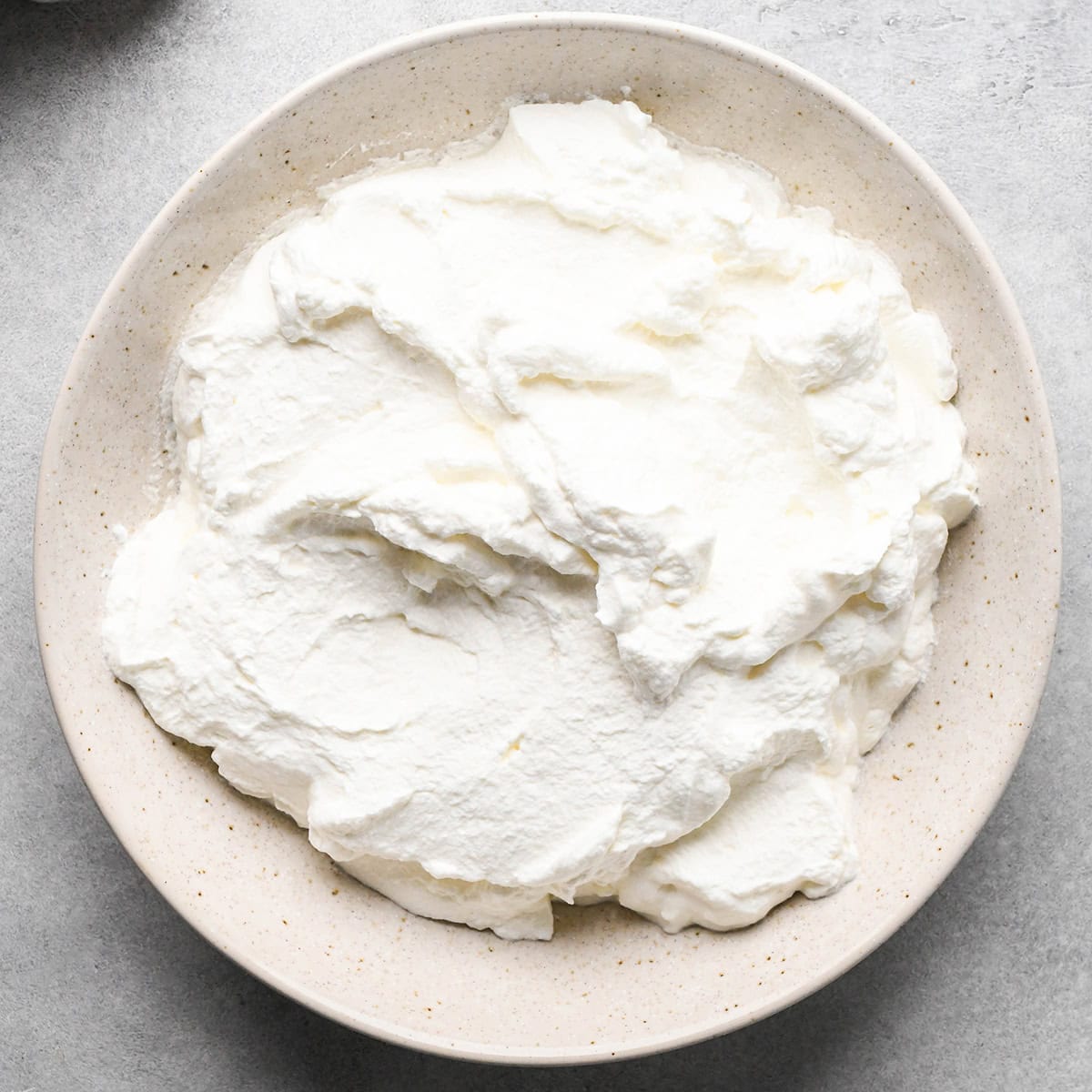whipped cream in a ceramic bowl making chocolate peanut butter pie