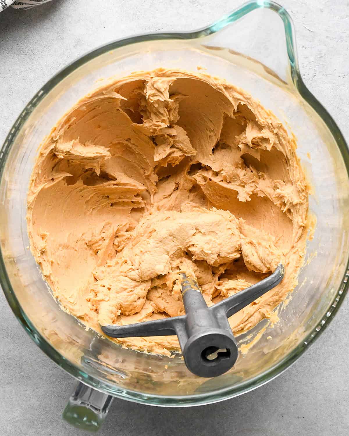 peanut butter and cream cheese mixture beaten together in a glass mixing bowl with the paddle attachment making chocolate peanut butter pie
