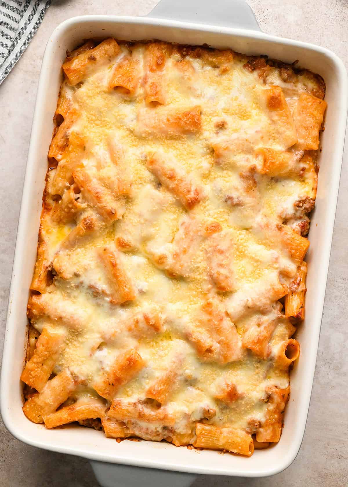 Baked ziti presented in a white casserole dish.