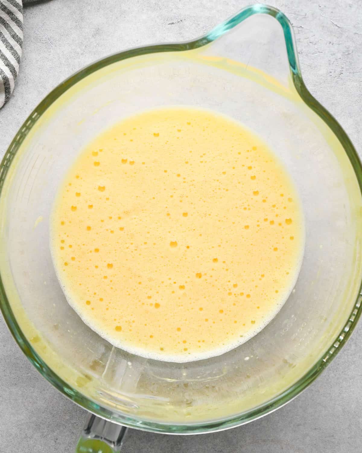 Making skillet brownies - 3 eggs cracked into a clear measuring bowl and whisked together