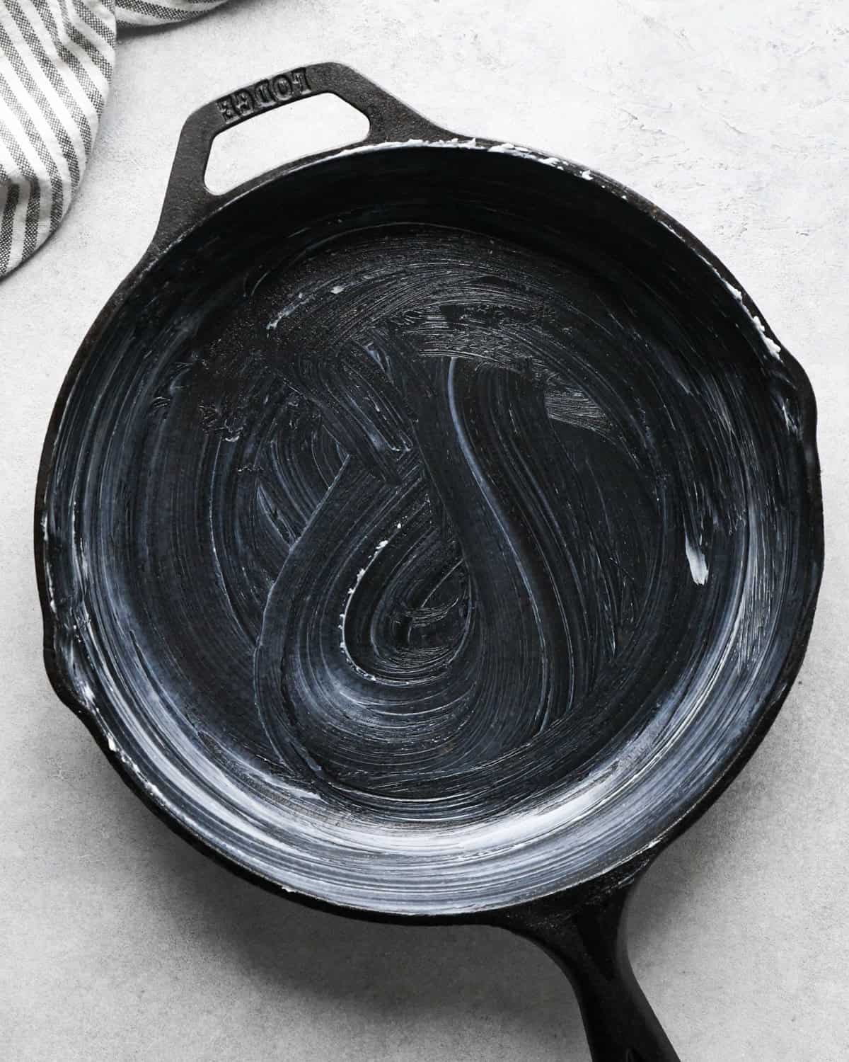 Overhead photo of a black cast iron skillet greased with butter