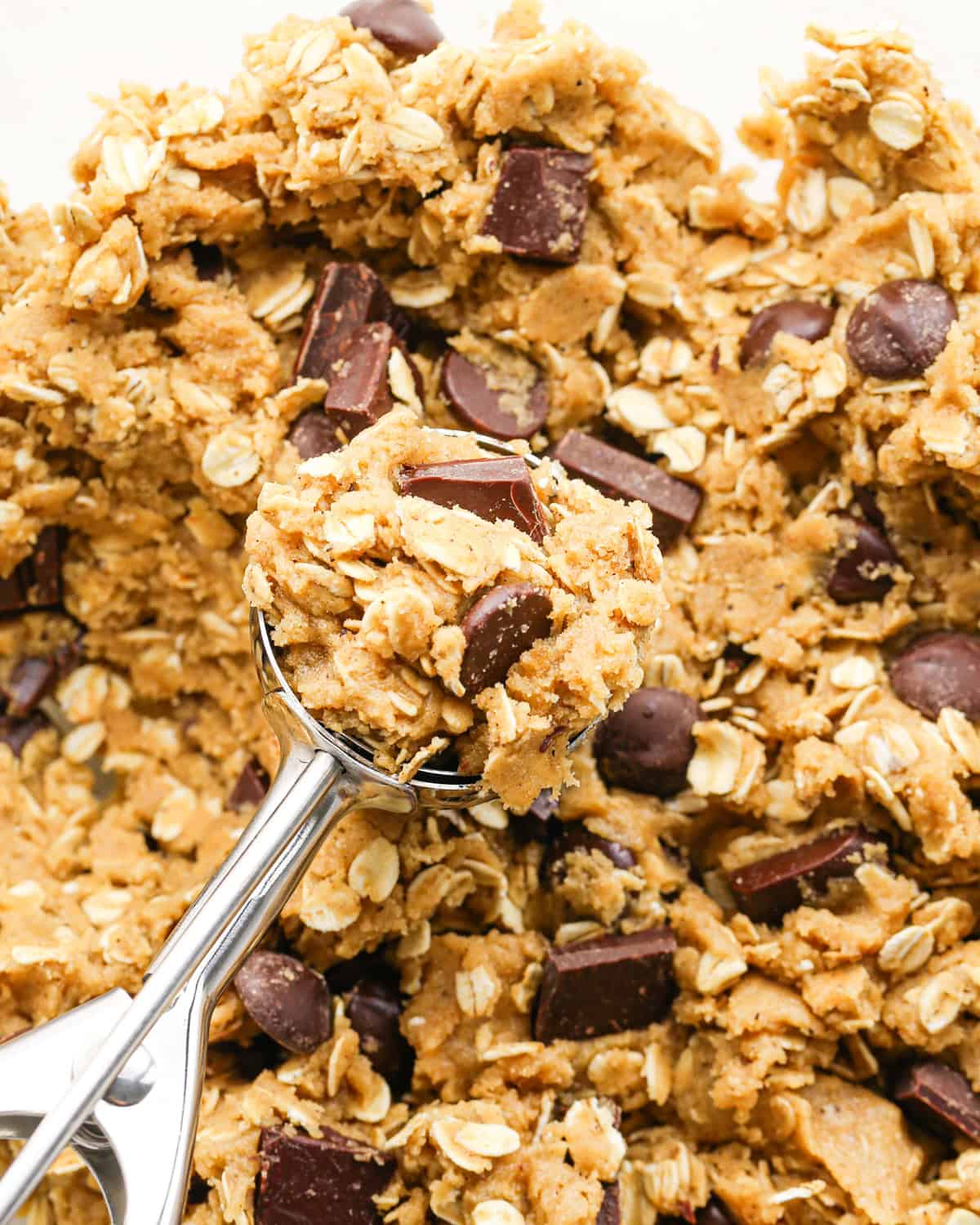 Making brown butter oatmeal cookies - overhead photo of completed cookie dough being scooped out with a cookie scoop.