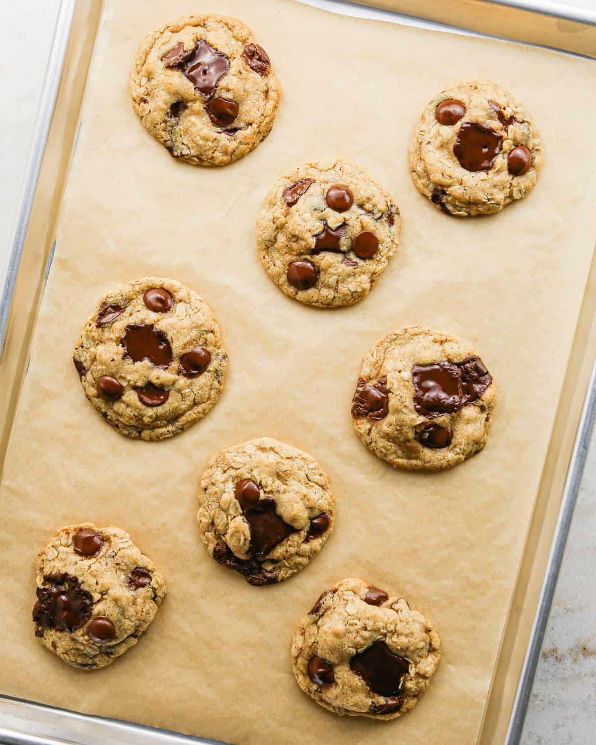Overhead photo of completed brown butter oatmeal cookies on parchment paper.