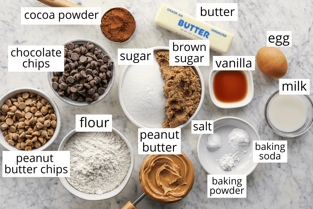 Labeled ingredients for chocolate peanut butter chip cookies, including flour, cocoa powder, sugars, peanut butter, butter, egg, milk, vanilla, baking powder, baking soda, salt, chocolate chips, and peanut butter chips.