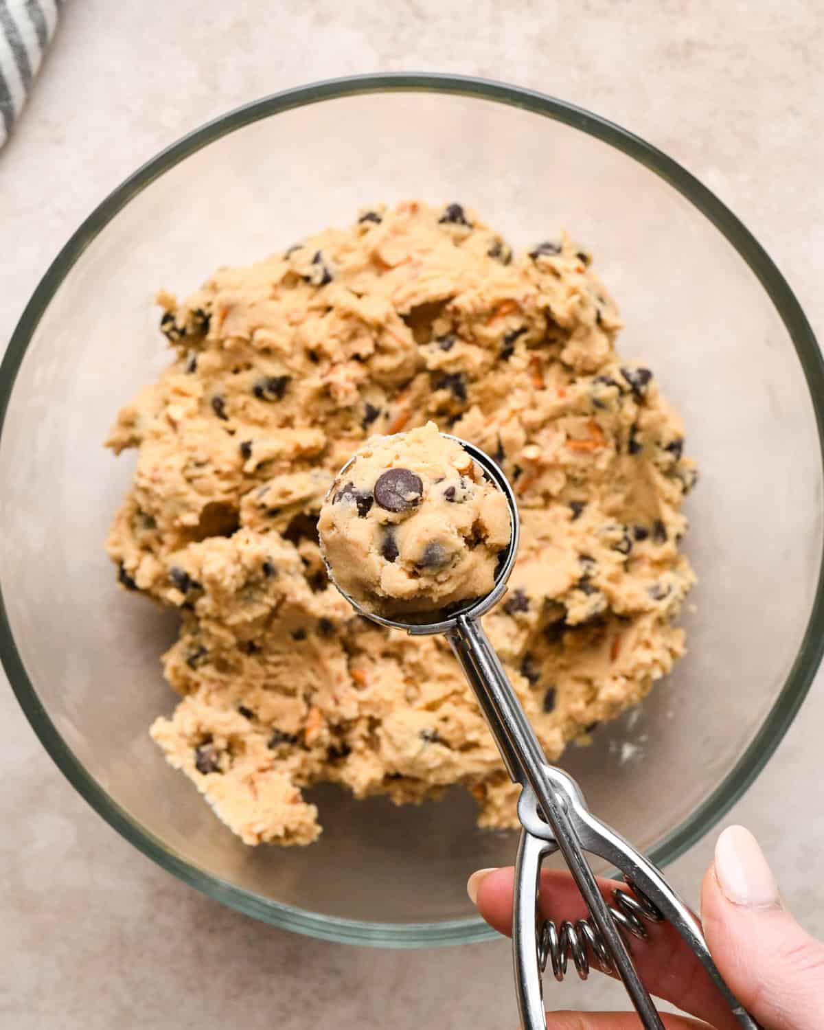 Making kitchen sink cookies - overhead photo of completed cookie dough being scooped out with a cookie scoop.