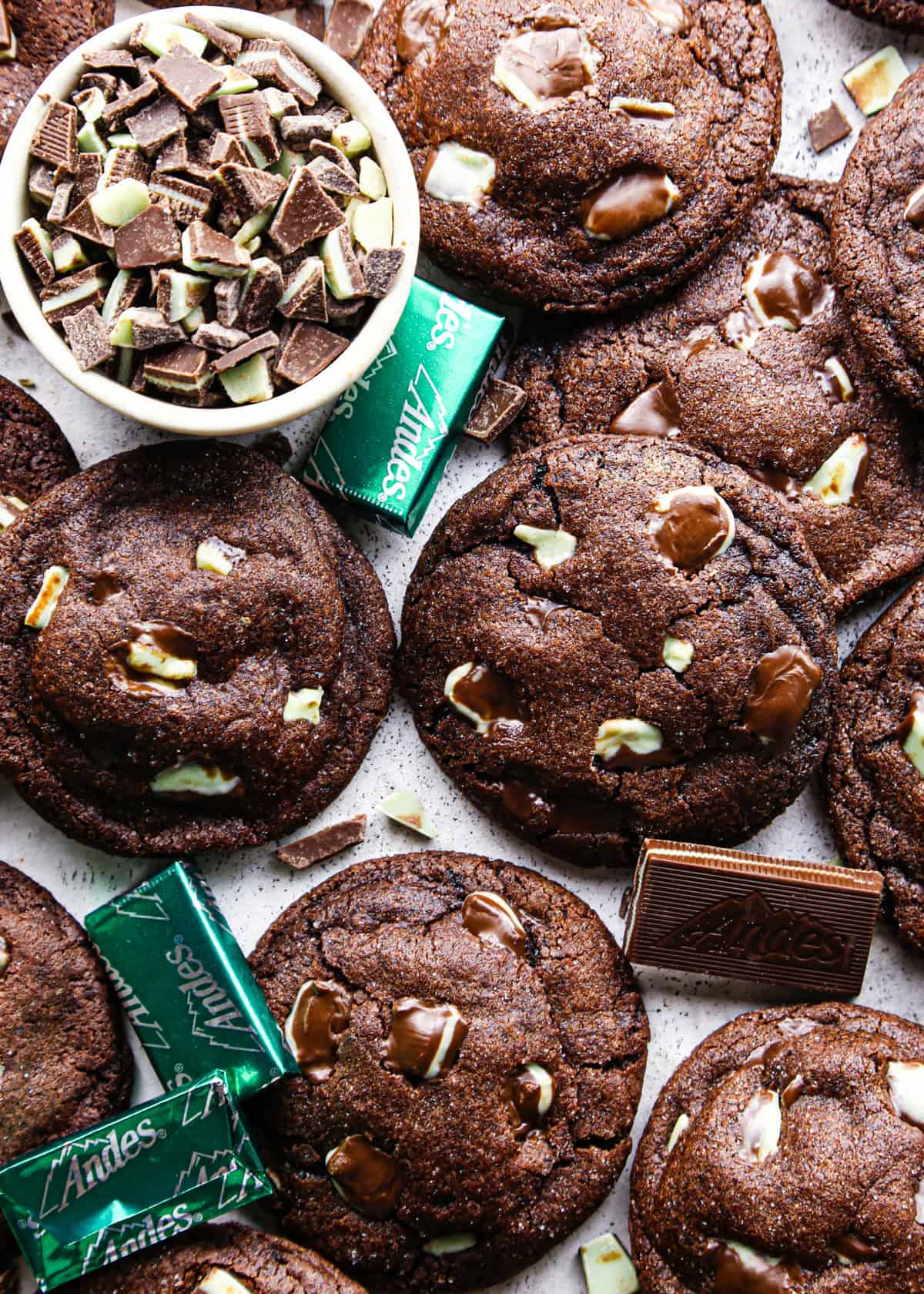 Overhead photo of chocolate mint cookies baked and ready to serve, surrounded by additional mint chocolate pieces.