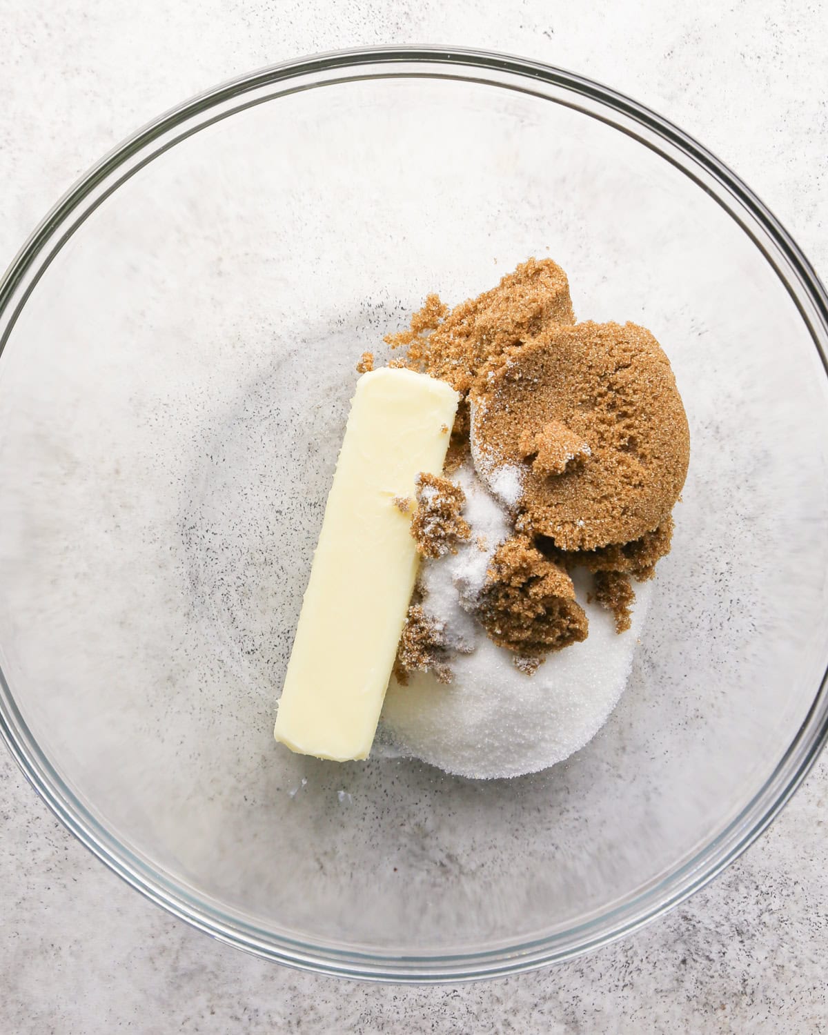 Making chocolate mint cookies - overhead photo of butter, sugar, and brown sugar in a clear mixing bowl.