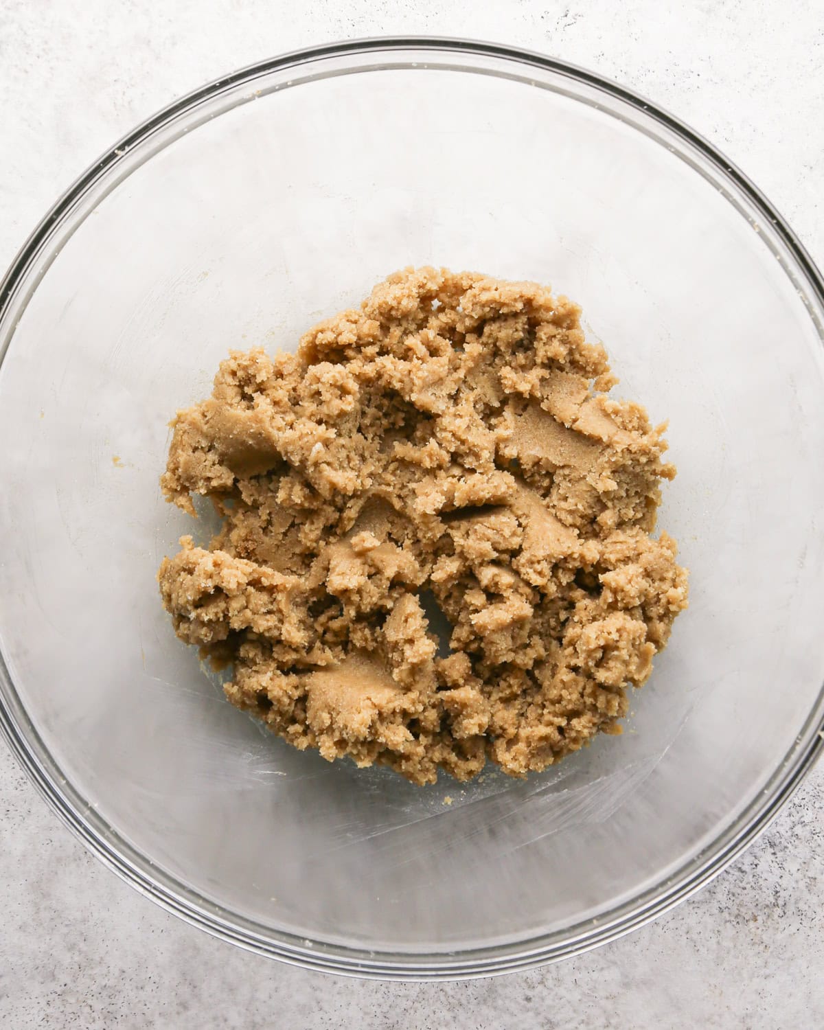 Making chocolate mint cookies - overhead photo of butter, sugar, and brown sugar in a clear mixing bowl and mixed together.
