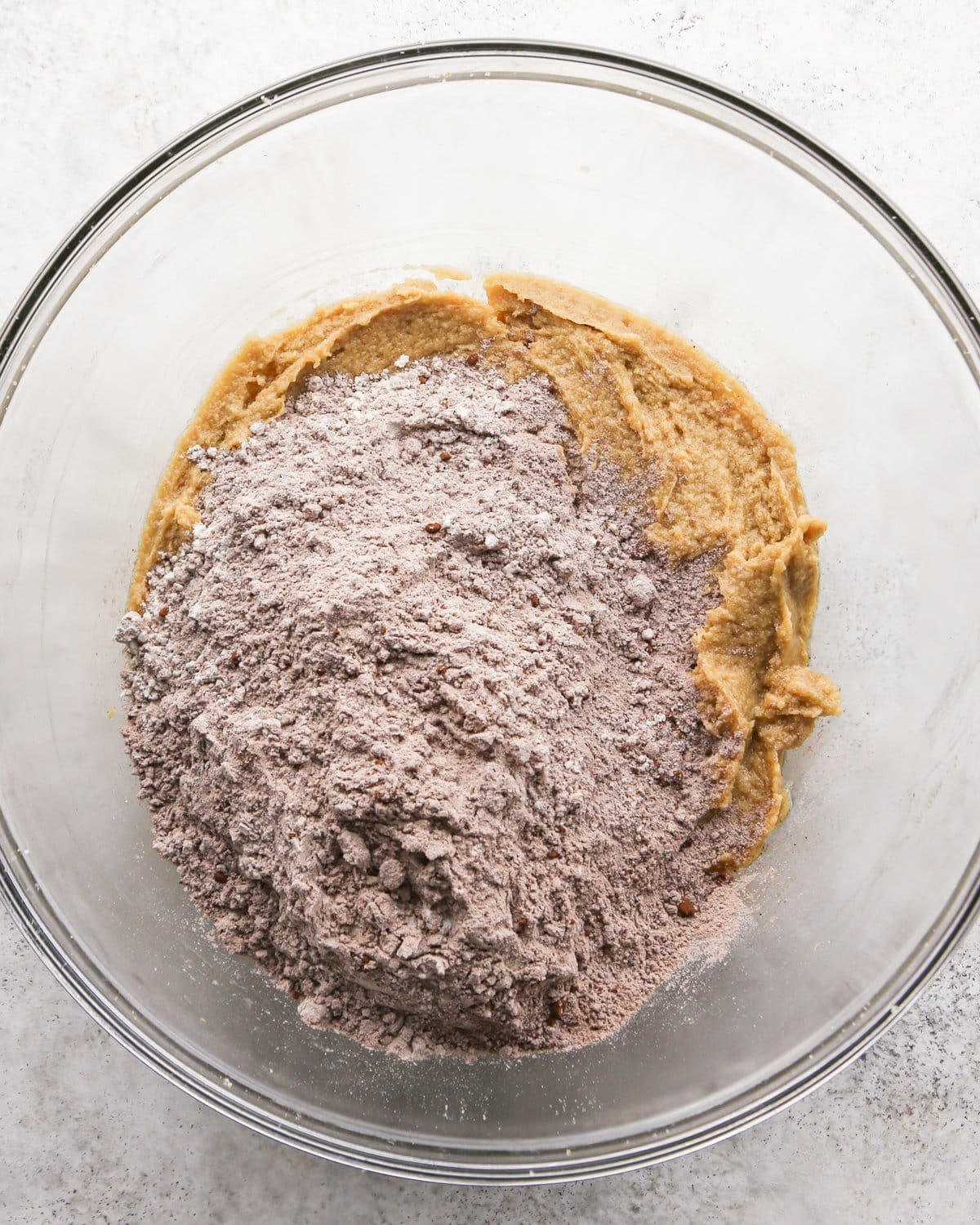 Making chocolate mint cookies - overhead photo of wet and dry ingredients being combined in a clear mixing bowl.