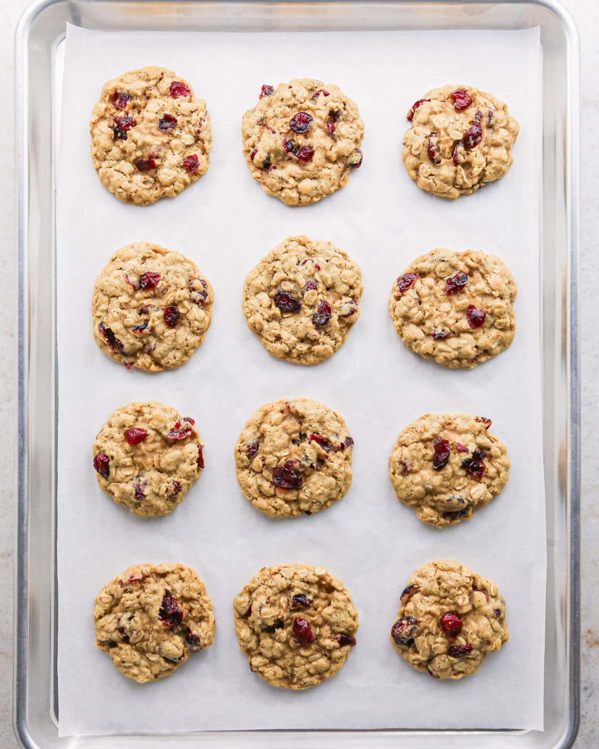 Making cranberry oatmeal cookies - overhead photo of 12 cranberry oatmeal cookies after being baked in the oven.