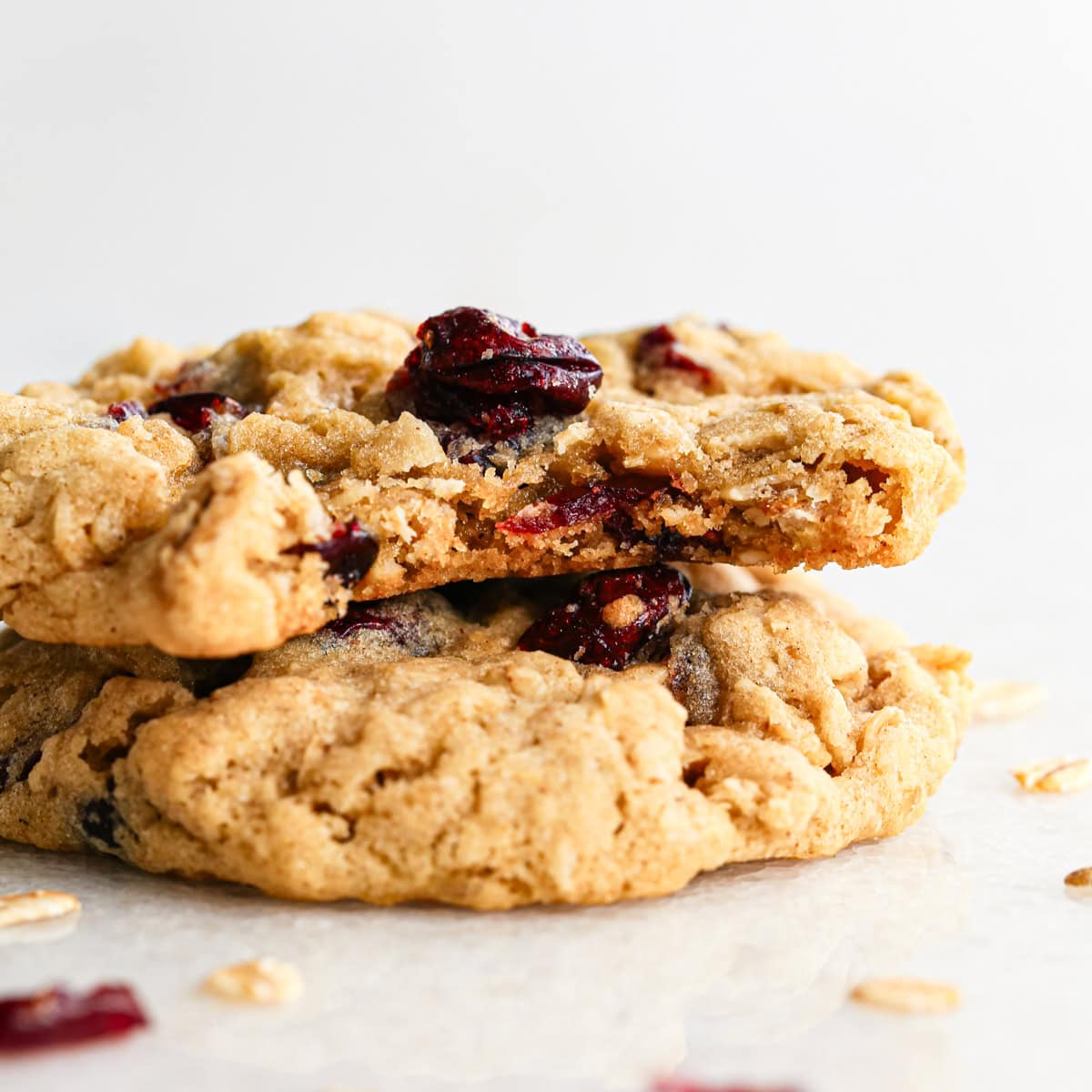 Close-up photo of a stack of 2 cranberry oatmeal cookies with a bite taken out of the top cookie.