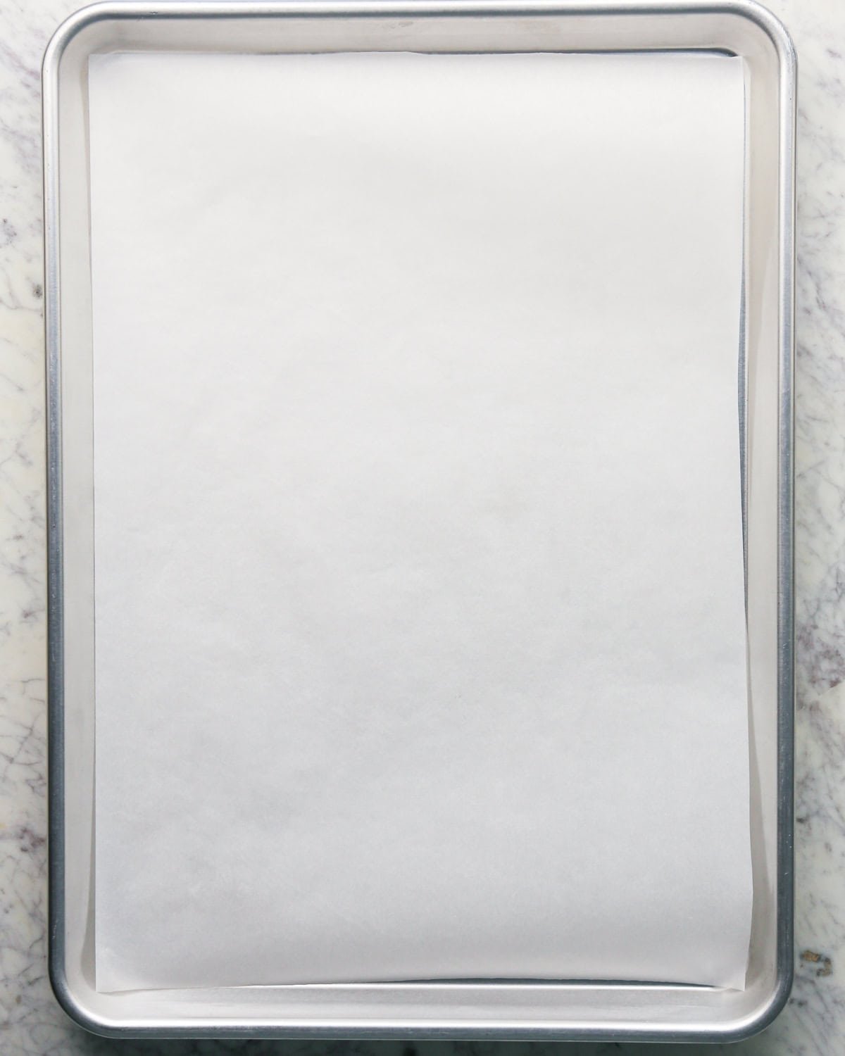 Overhead photo of a baking sheet covered by a sheet of parchment paper.
