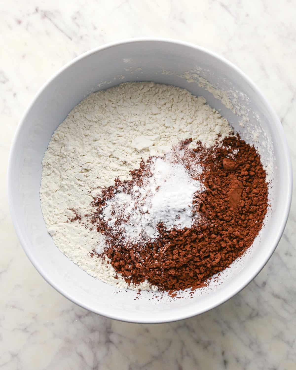 Making chocolate peanut butter chip cookies - dry ingredients placed in a white bowl.