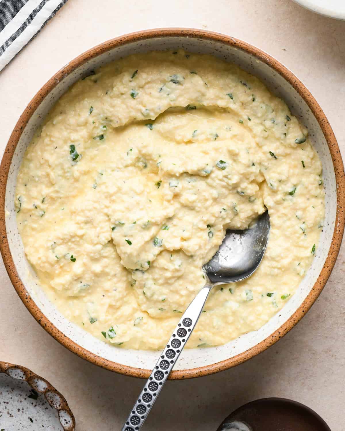 Making stuffed manicotti - overhead photo of stuffed manicotti filling ingredients mixed together in a large white bowl with a spoon.