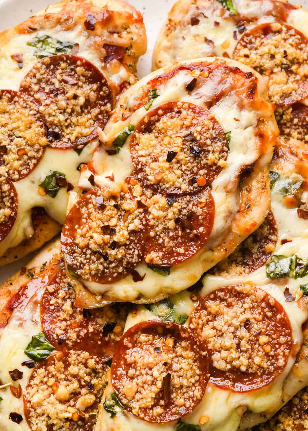 Making pizza chicken: close-up photo of completed meal being served on a white speckled plate.