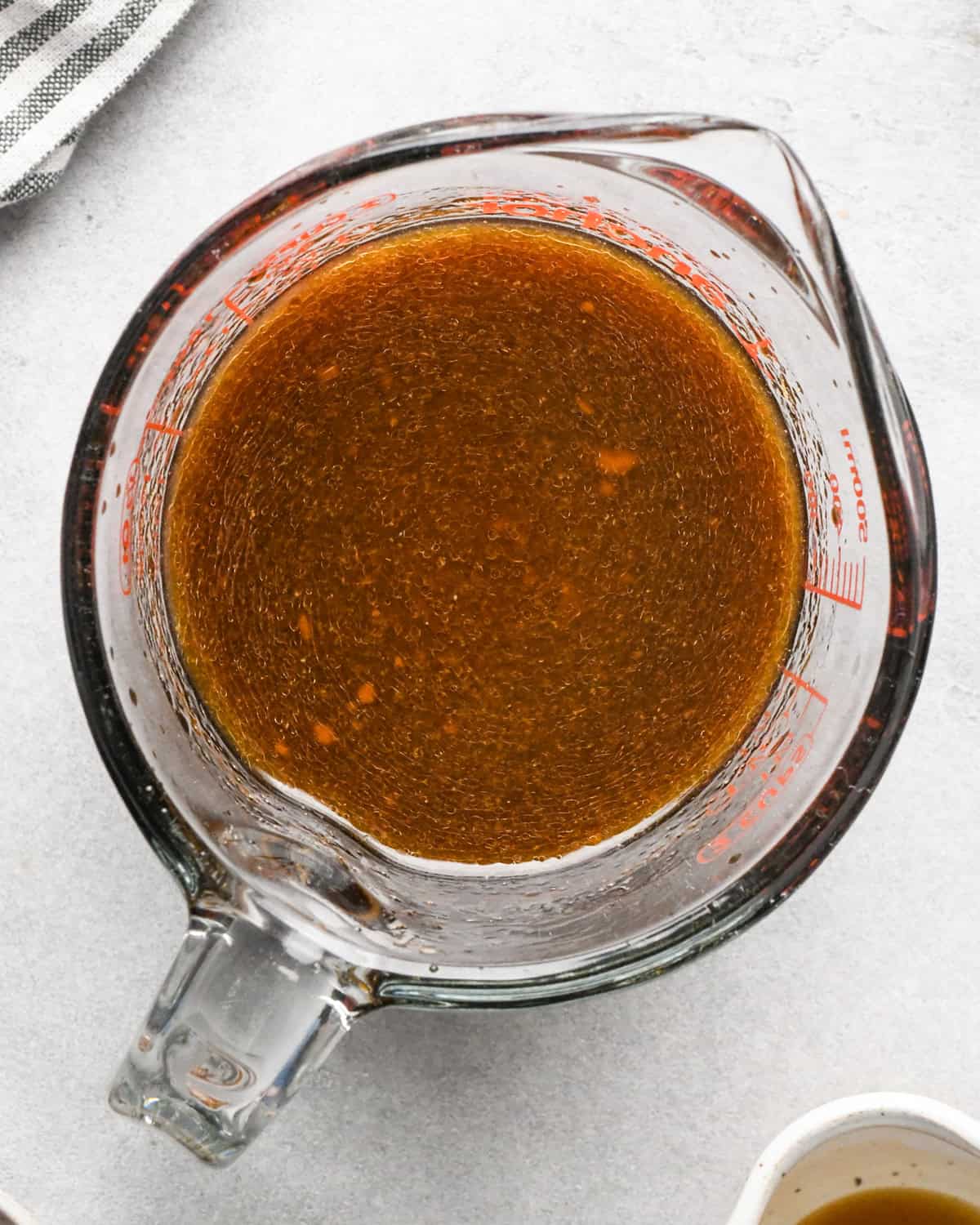Making beef and broccoli: the ingredients for the sauce are mixed together in a liquid measuring cup.