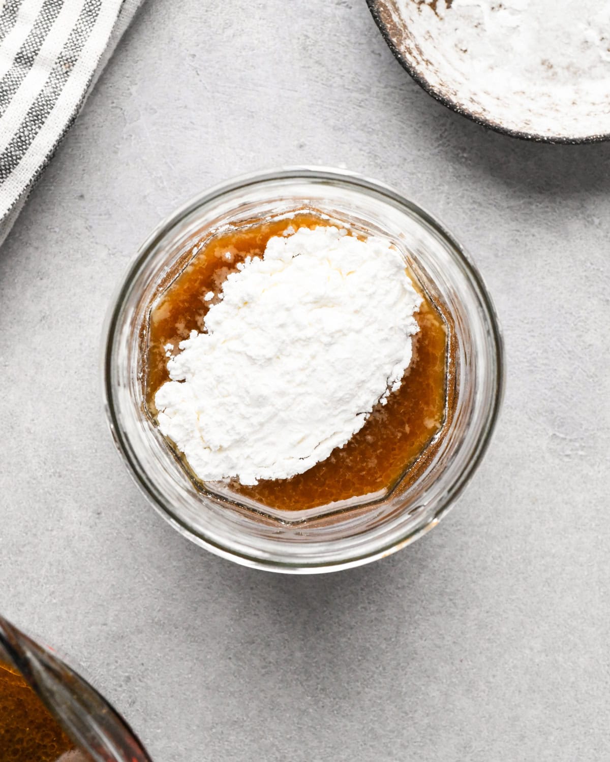 Making beef and broccoli: overview photo of sauce ingredients being added to a clear bowl.