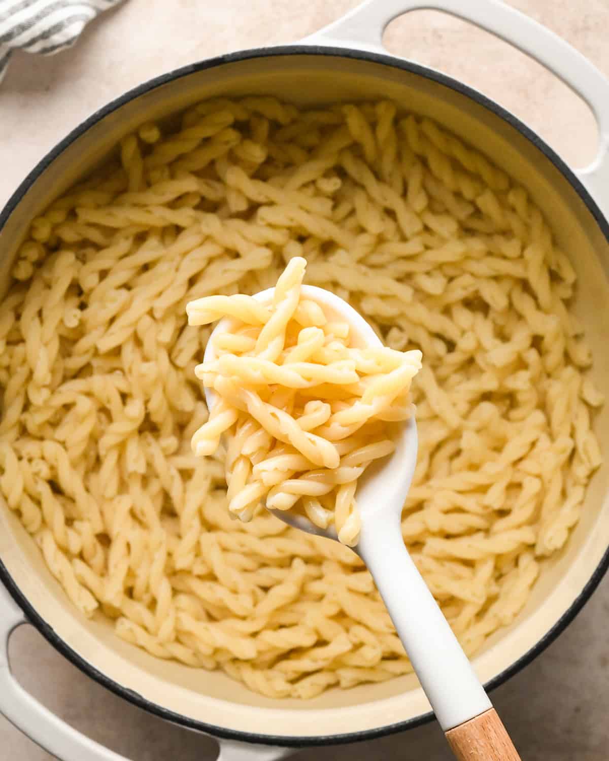 Making sausage pasta: overhead photo of pasta being cooked in a white pot.