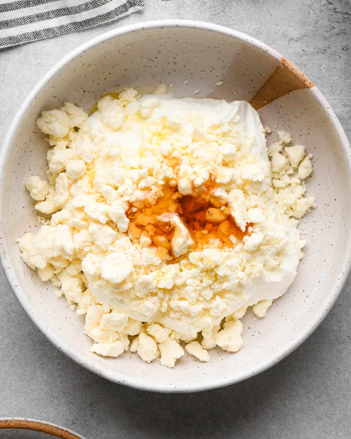 Making Greek chicken salad: beginning to mix the creamy dressing ingredients in a white speckled bowl.