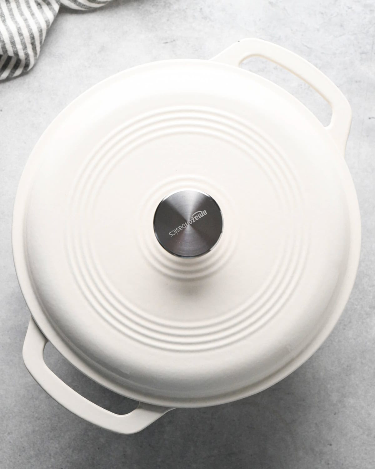 a white dutch oven with the lid on showing how to cook oatmeal
