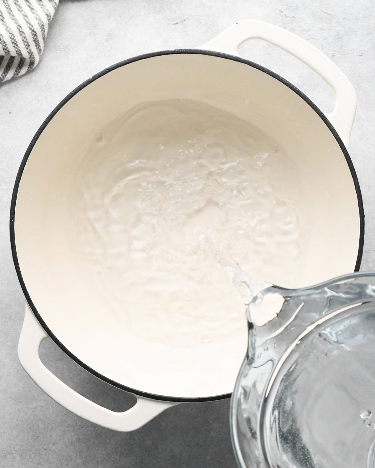 water being poured into a pot showing how to make oatmeal