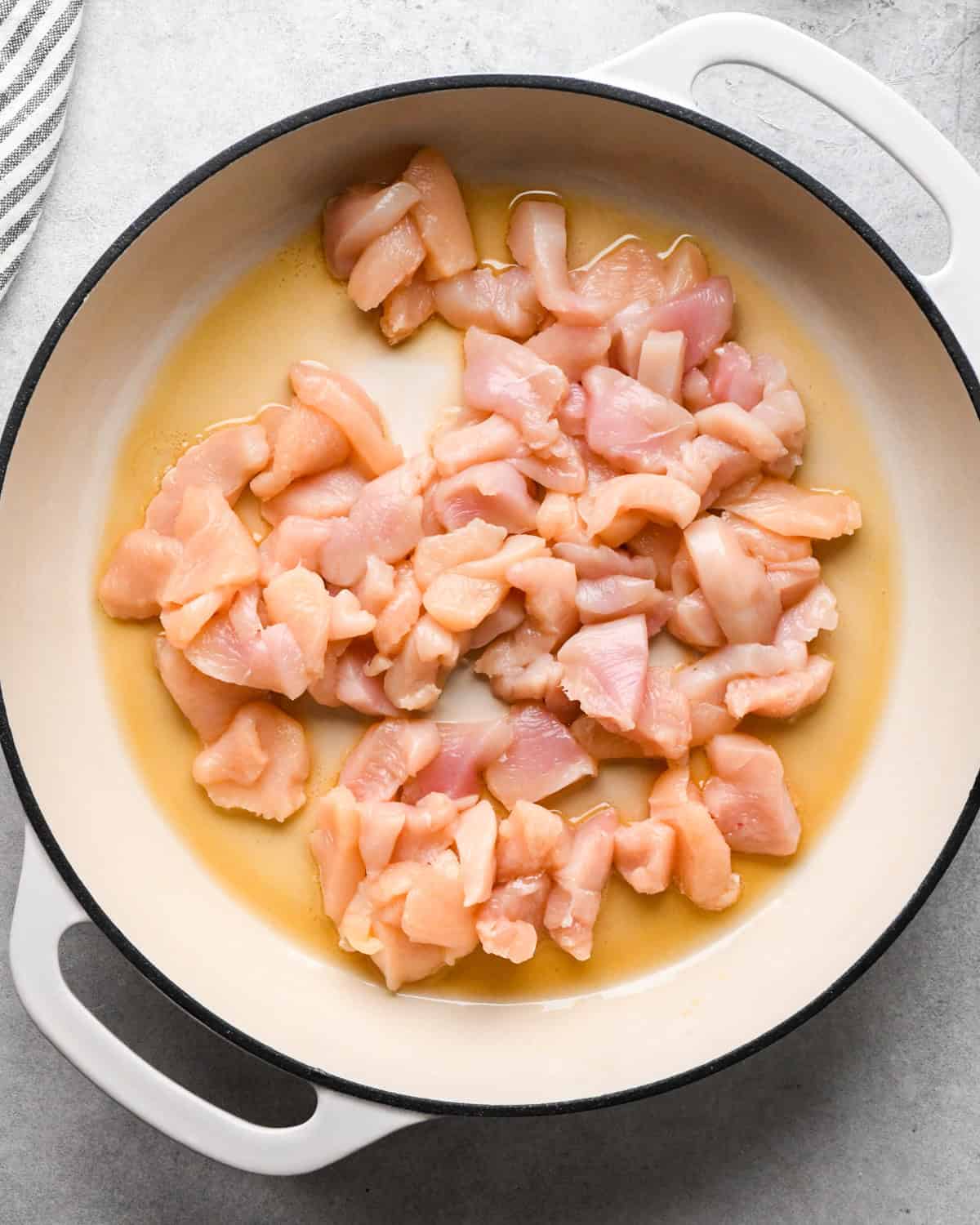 Making chicken fried rice: overhead photo of chicken being cooked in a white skillet.