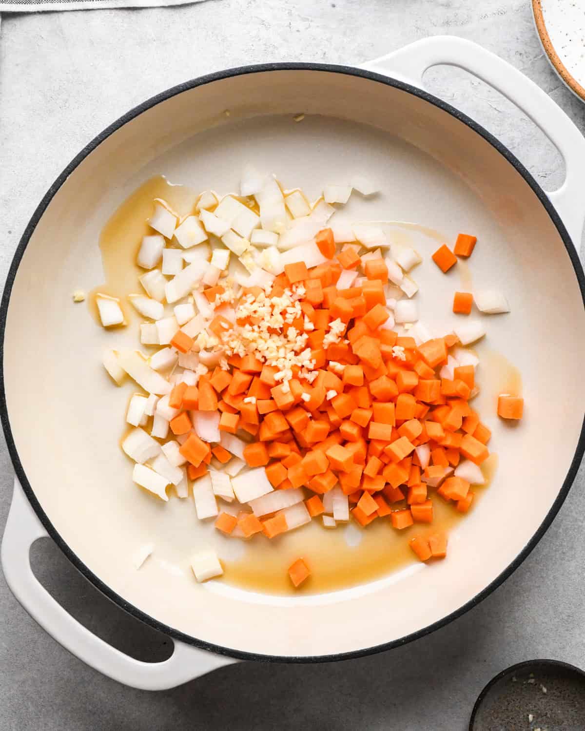 Making chicken fried rice: overhead photo of vegetables being added to a white skillet.
