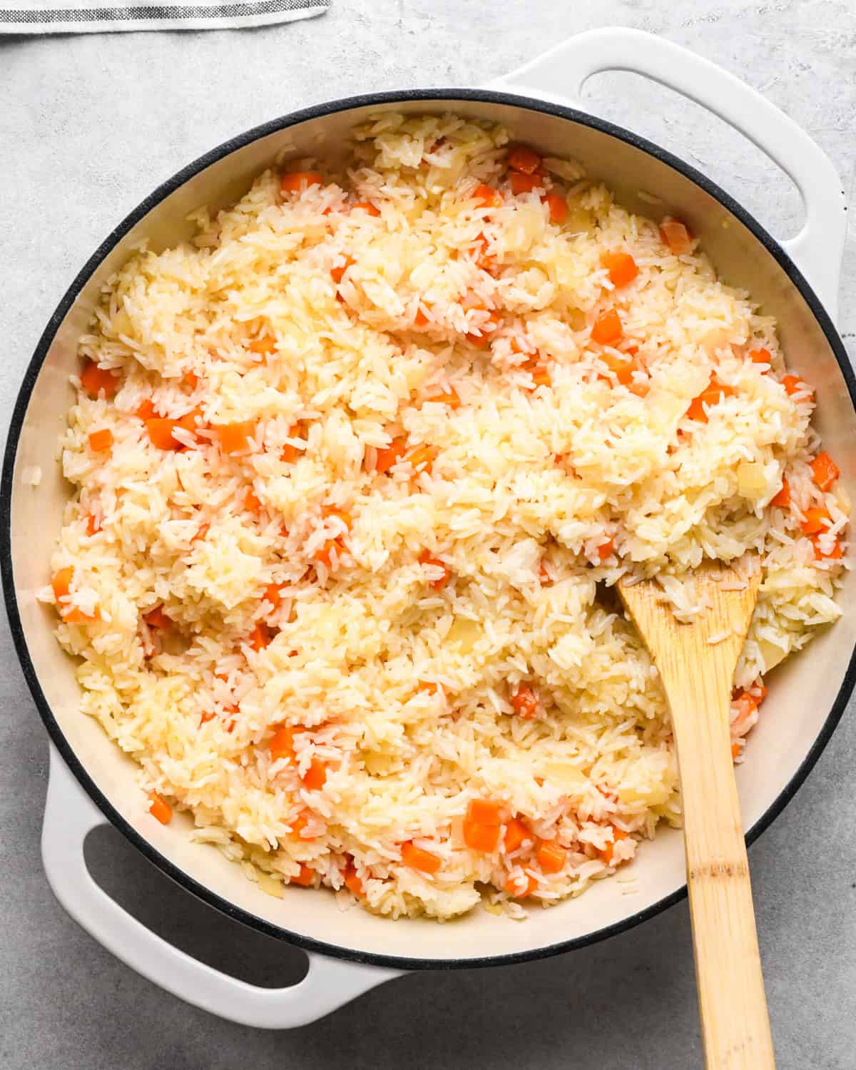 Making chicken fried rice: rice is added to the skillet with cooked vegetables and mixed together.