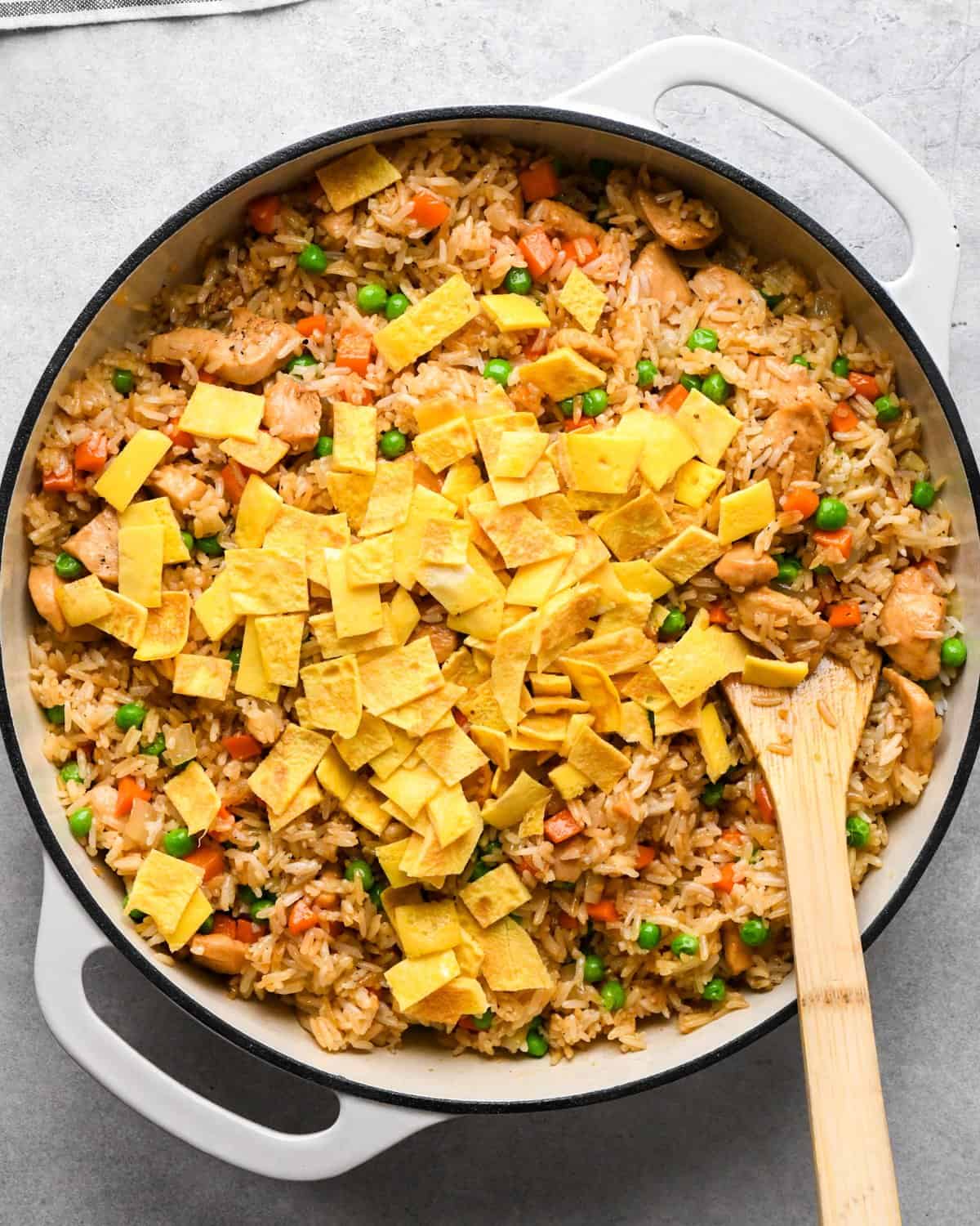 Making chicken fried rice: prepared eggs are added to the skillet with the rice, chicken, and vegetables.