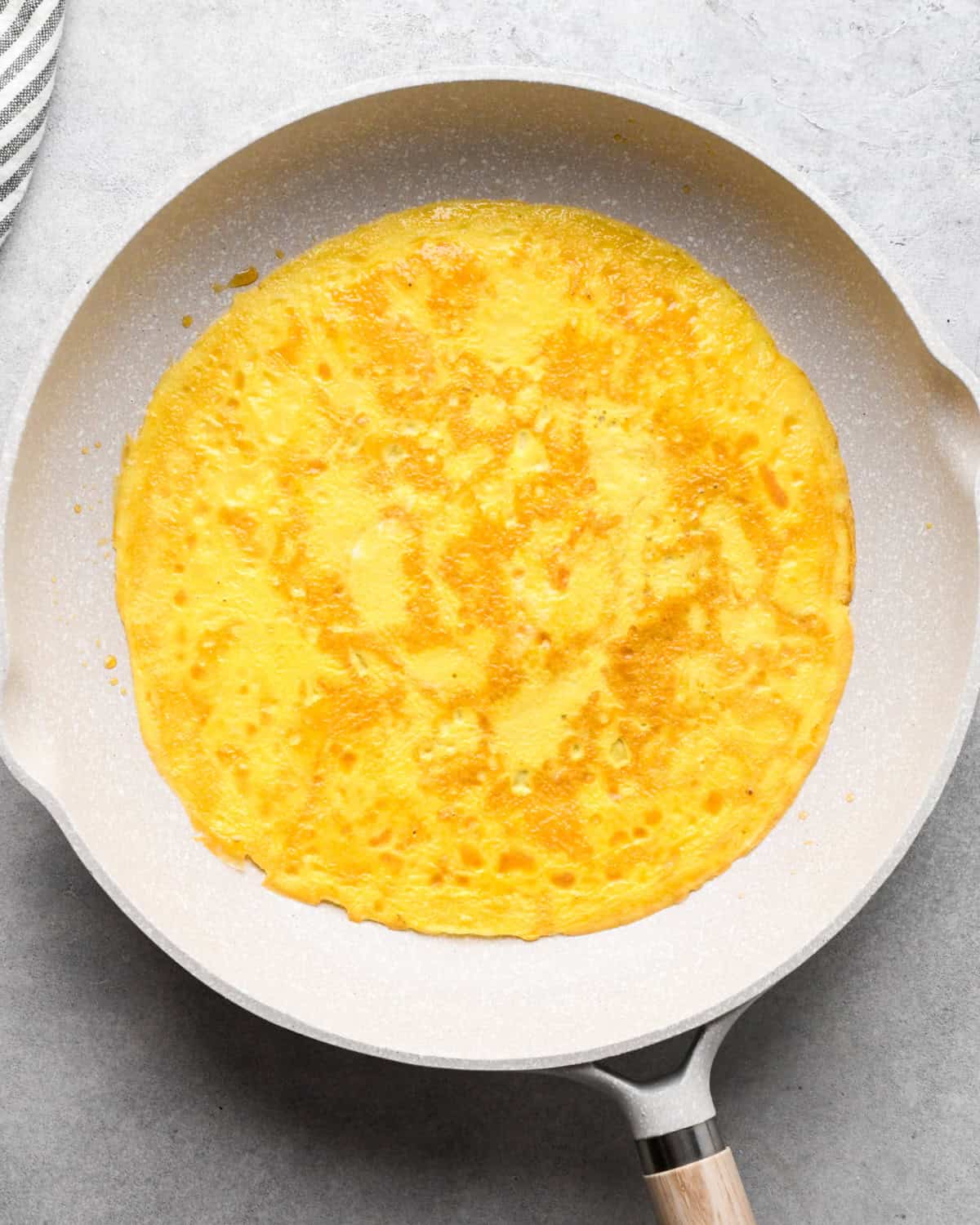 Making chicken fried rice: overhead photo of eggs being cooked in a white skillet.