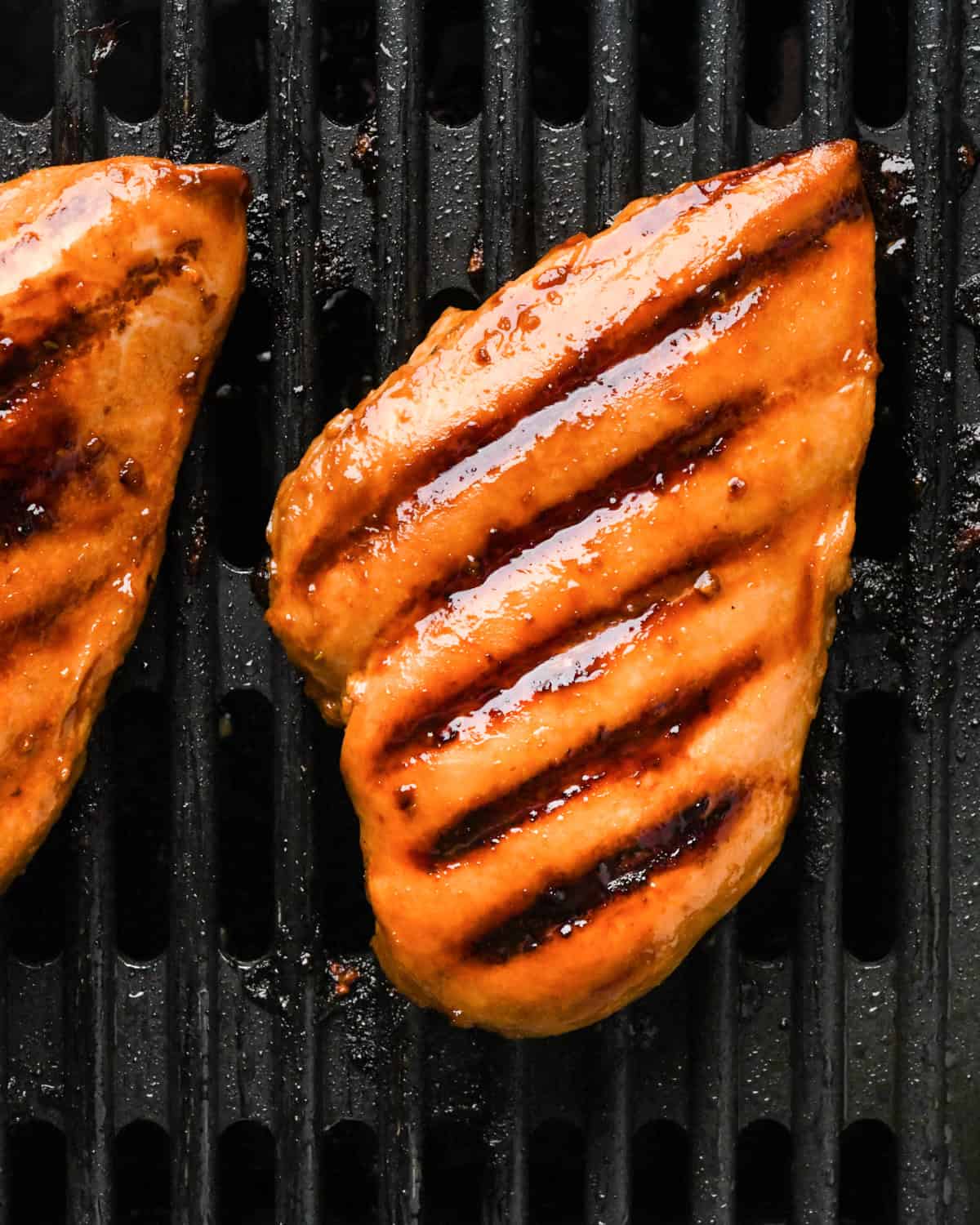 Making teriyaki chicken: close-up photo of marinated chicken on a grill.
