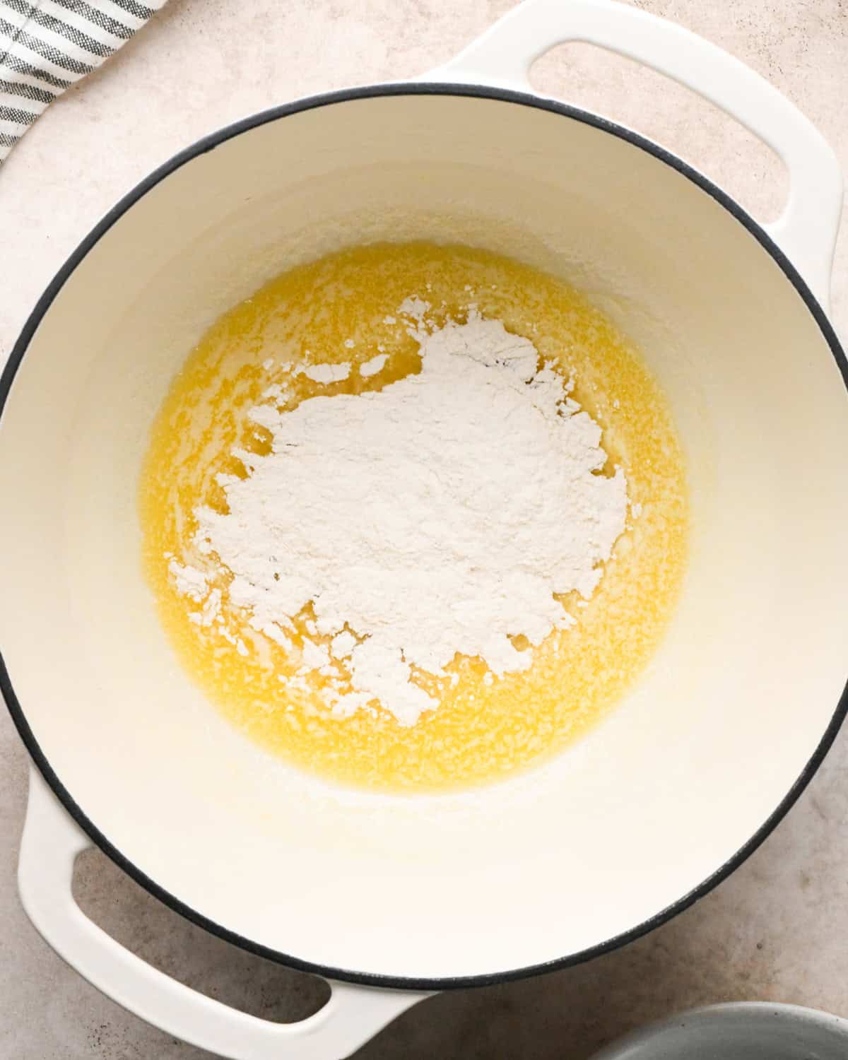 Making broccoli macaroni and cheese (mac and cheese): overhead photo of wet and dry ingredients for homemade cheese sauce being combined in a large pot.
