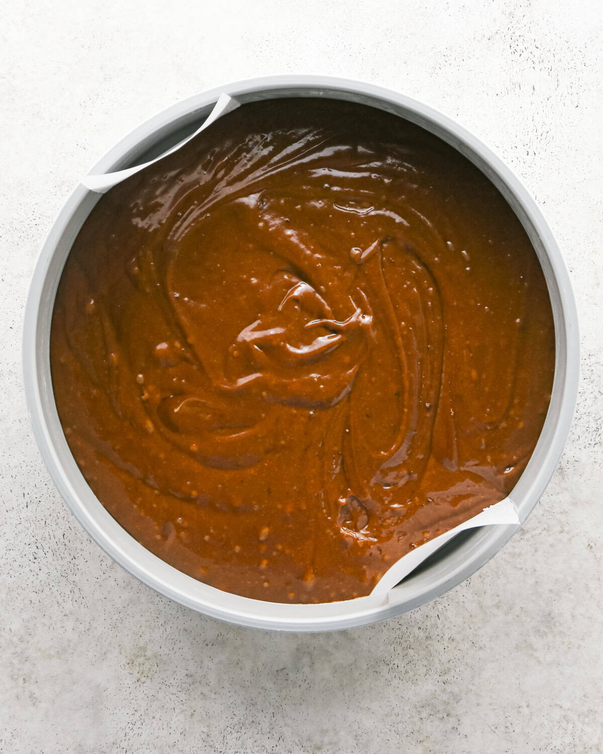 olive oil chocolate cake batter spread into the prepared cake pan before baking