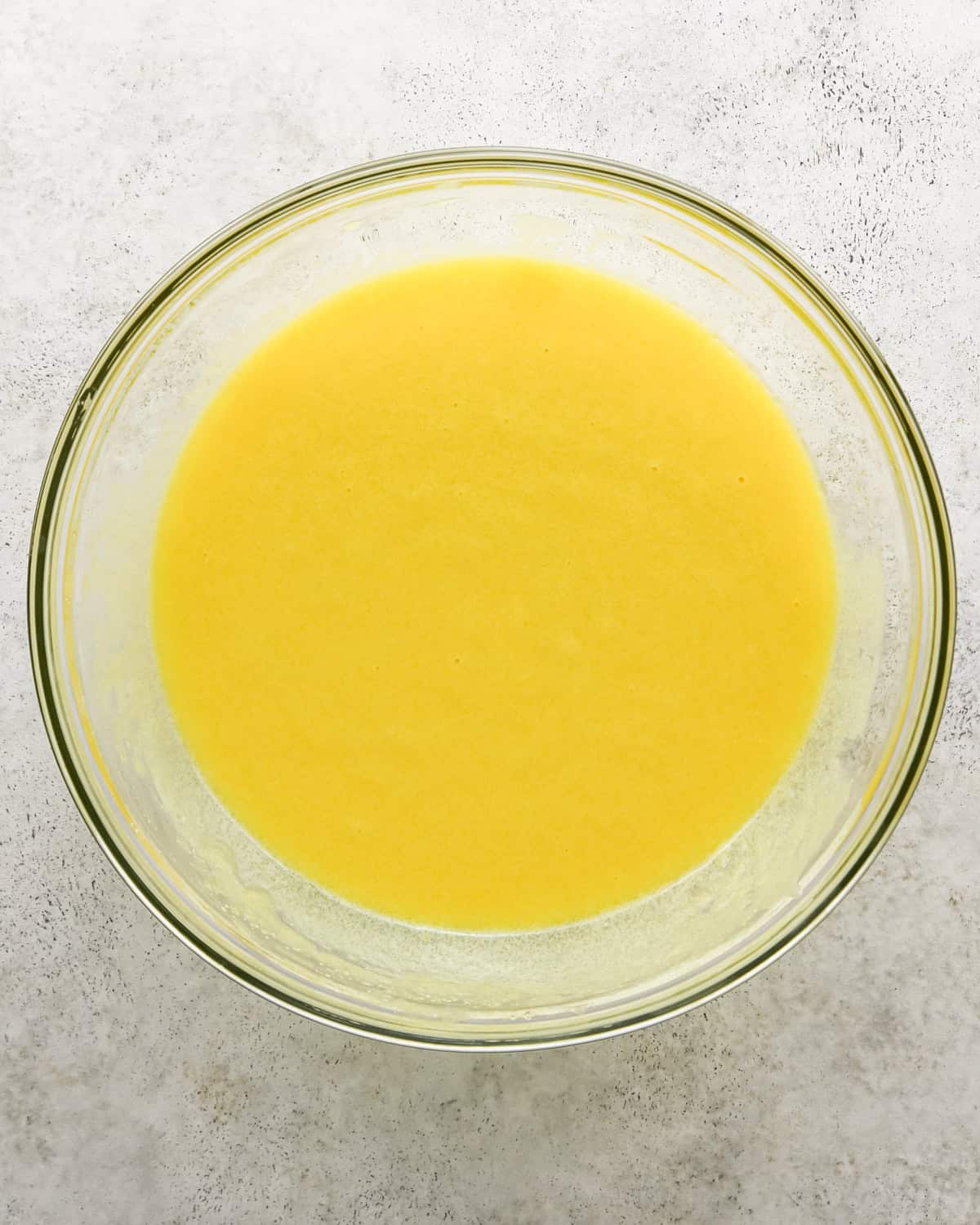 making chocolate olive oil cake - eggs, olive oil, sugar, sour cream and vanilla in a bowl after whisking